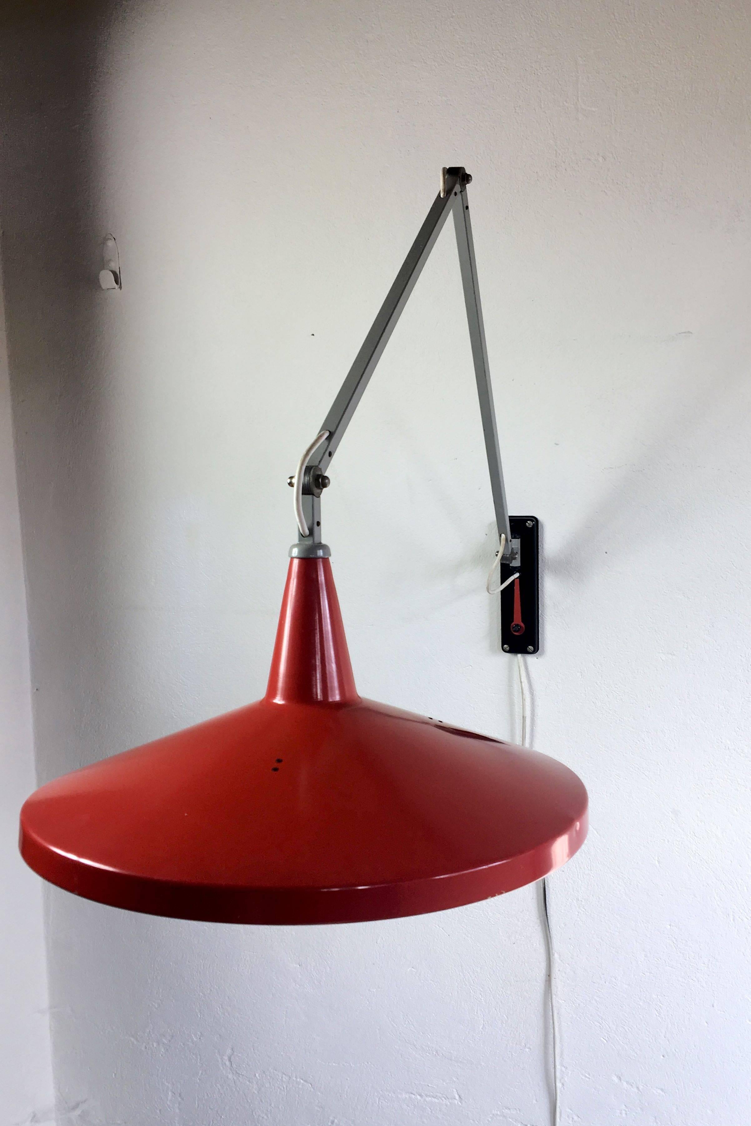 A true Dutch design Classic, this Gispen Giso 4050 designed by Wim Rietveld in 1953 quickly became known as the 'panama hat' lamp for its distinctive shape.

The arm has three points of articulation and the lamp includes a small red wrench