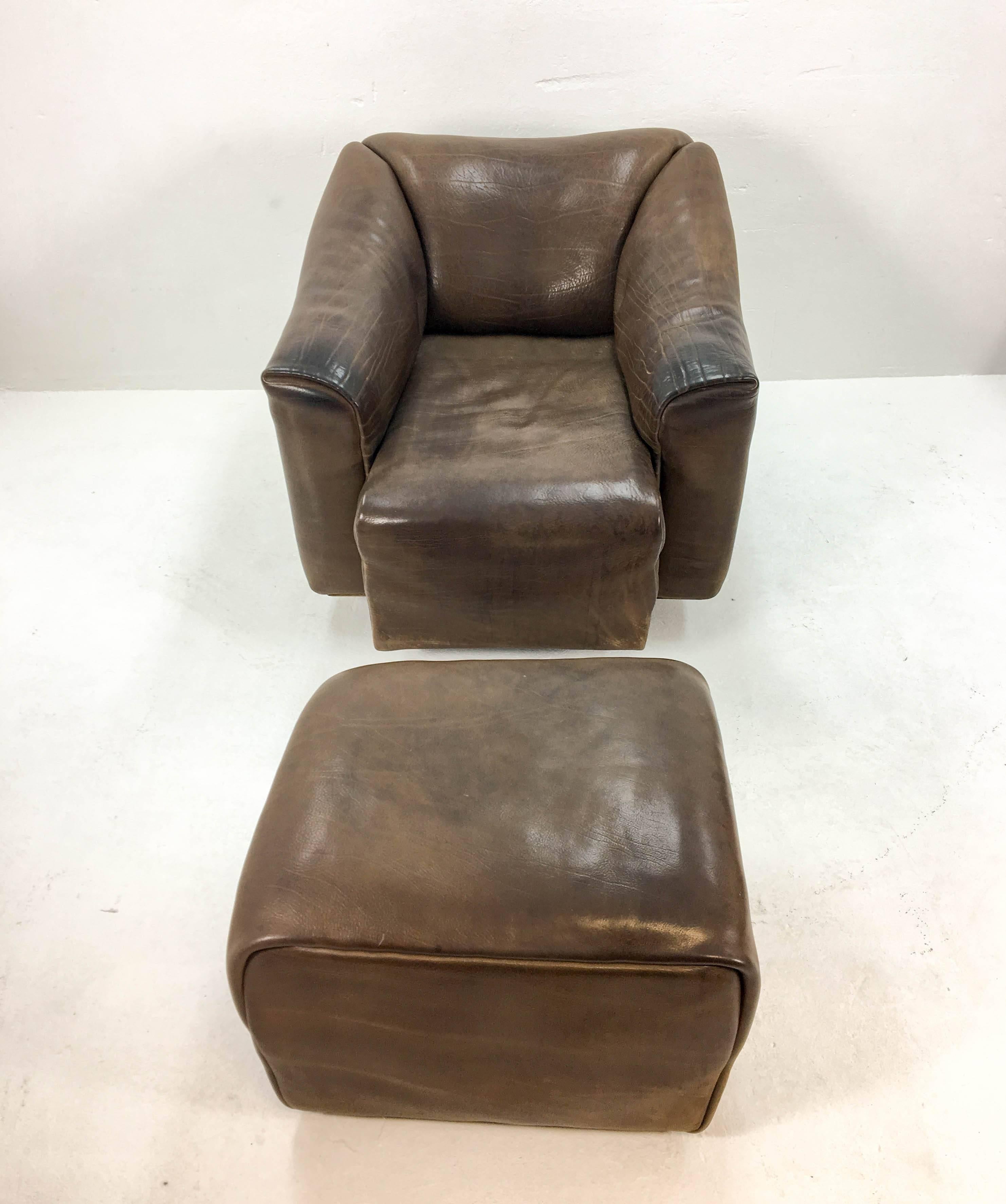 Great lounge chair in with matching ottoman from De Sede Switzerland, early 1970s. Very thick neck leather with a beautiful patina on a massive wooden frame. The seat can slide forward some 20cm for an even more relaxing seating position. Amazing