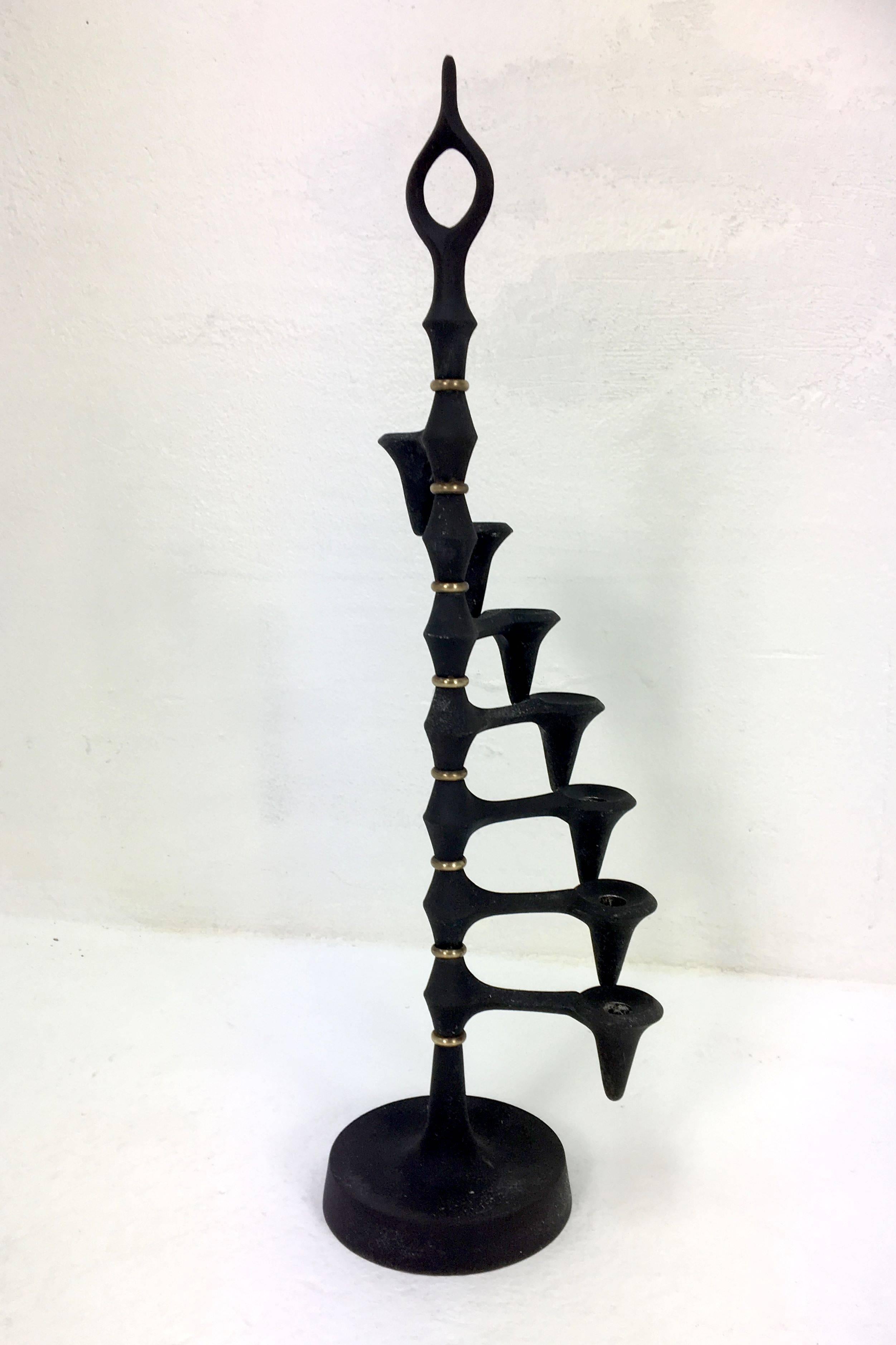 Cast-iron candle tree designed by Jens Quistgaard for Dansk. The seven arms can be rotated freely into any desired shape.