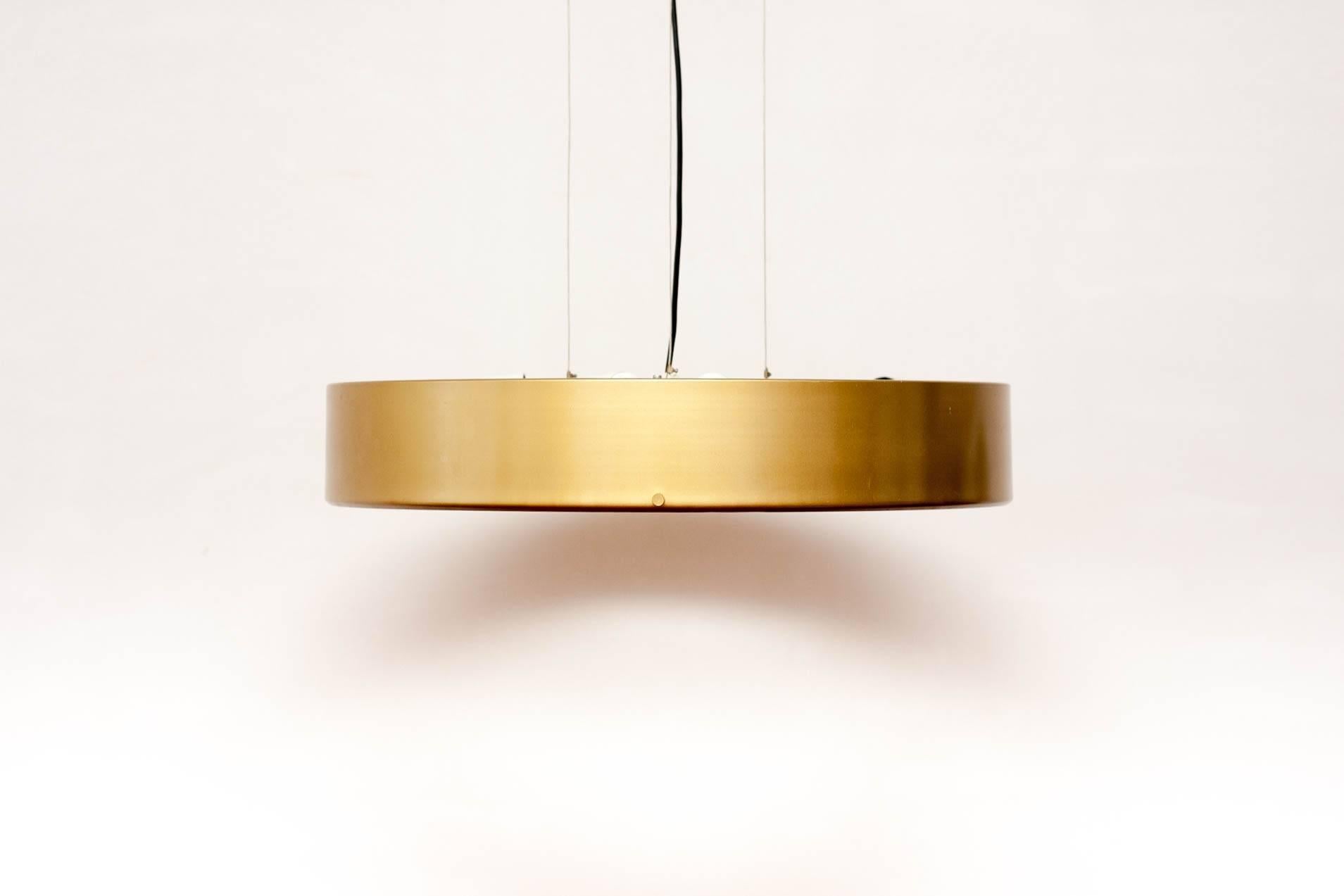 Large pendant light designed by Stilnovo founder Bruno Gatta, 1959. Rare original golden color. The lamp is suspended from a ceiling plate by three metal wires each which can be adjusted to change height and each pendant lamp holds six armatures.

  