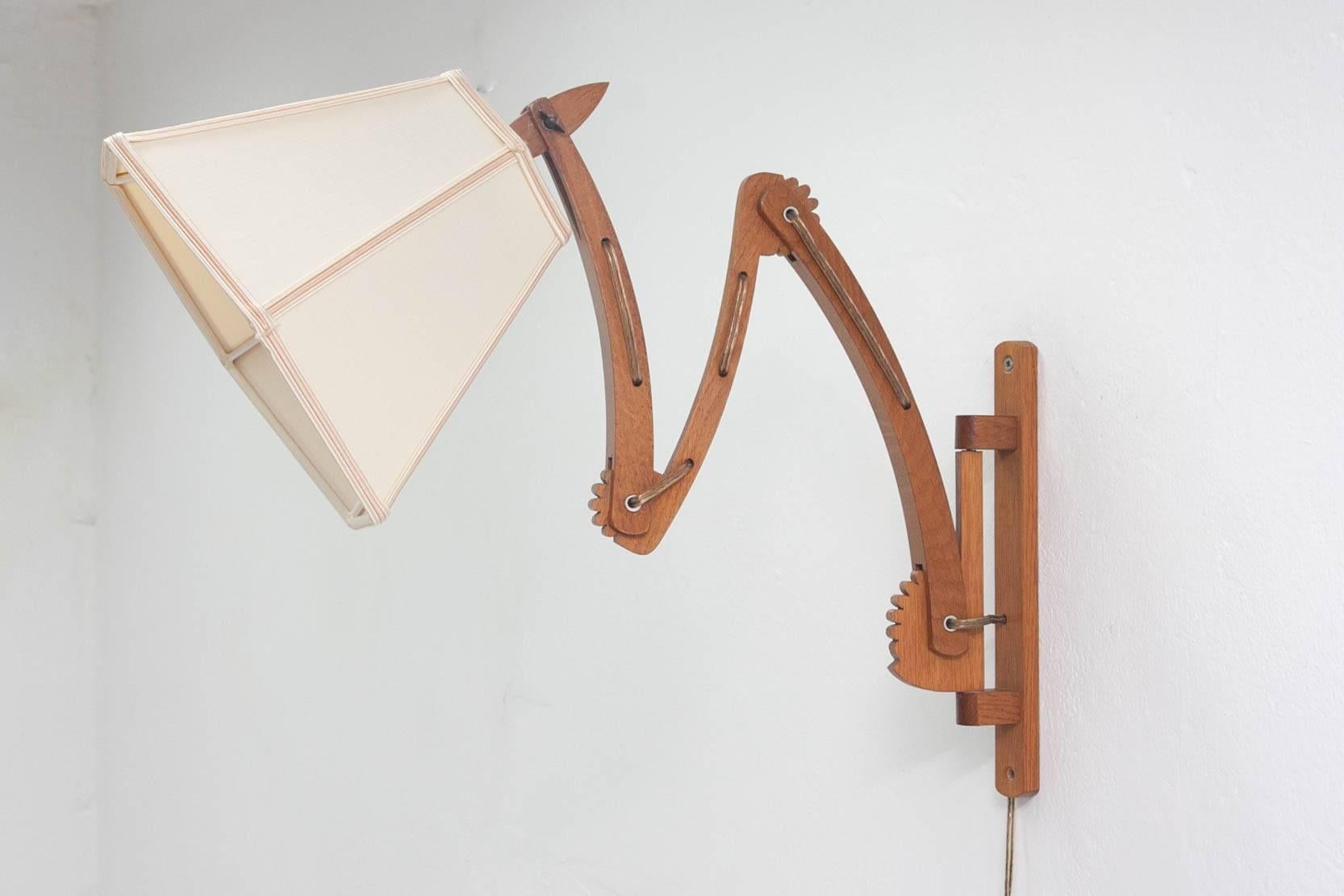 Quirky Dutch wall light from the 1950s incorporating a patented scissor system allowing the lamp to lock into almost any position imaginable using a ratcheting mechanism. Very nice functional lamp with an unusual look.