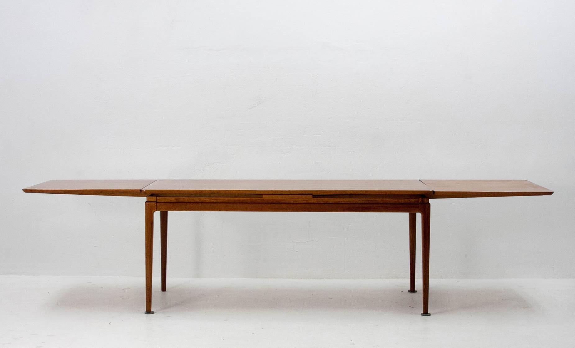 Beautiful and generously sized coffee table in Danish teak veneer. Designed by Johannes Andersen for C.F.C. Silkeborg. Base width is 120cm and it extends to 220cm with both sides slid out.