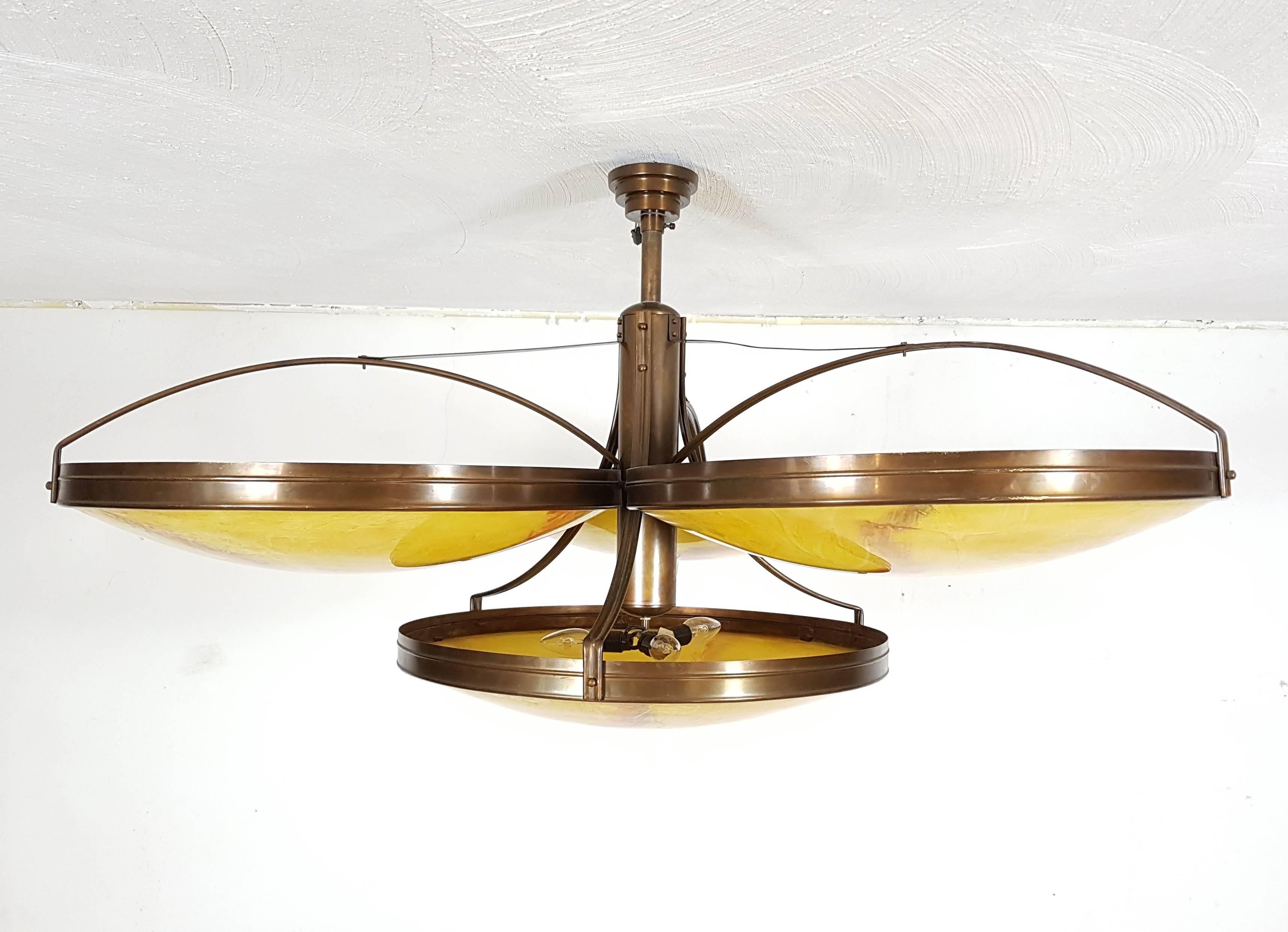 Four quality custom-made reproduction Art Deco pendant lamps consisting of four clustered bowls each. Brass finish and marbled glass bowls holding three armatures each. At a total diameter of 120cm these are very large and impressive lamps.