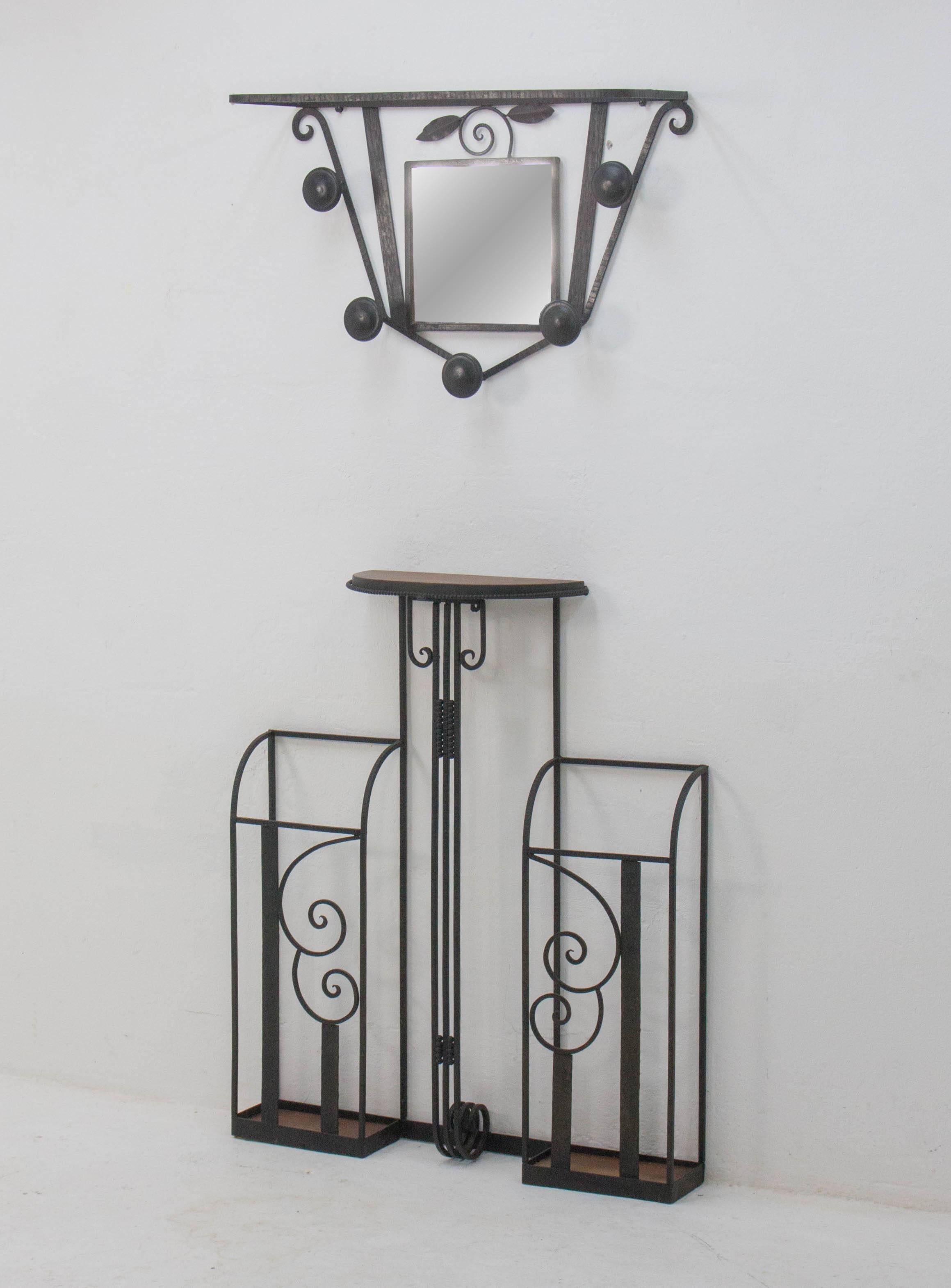 Graceful Dutch art deco wall-mounted hallway set consisting of an umbrella stand and a coat rack incorporating a small mirror. Cast iron and oak.

The lower umbrella stand part is 86cm tall, 72.5cm wide and 17cm deep, the upper coatrack part is 41cm