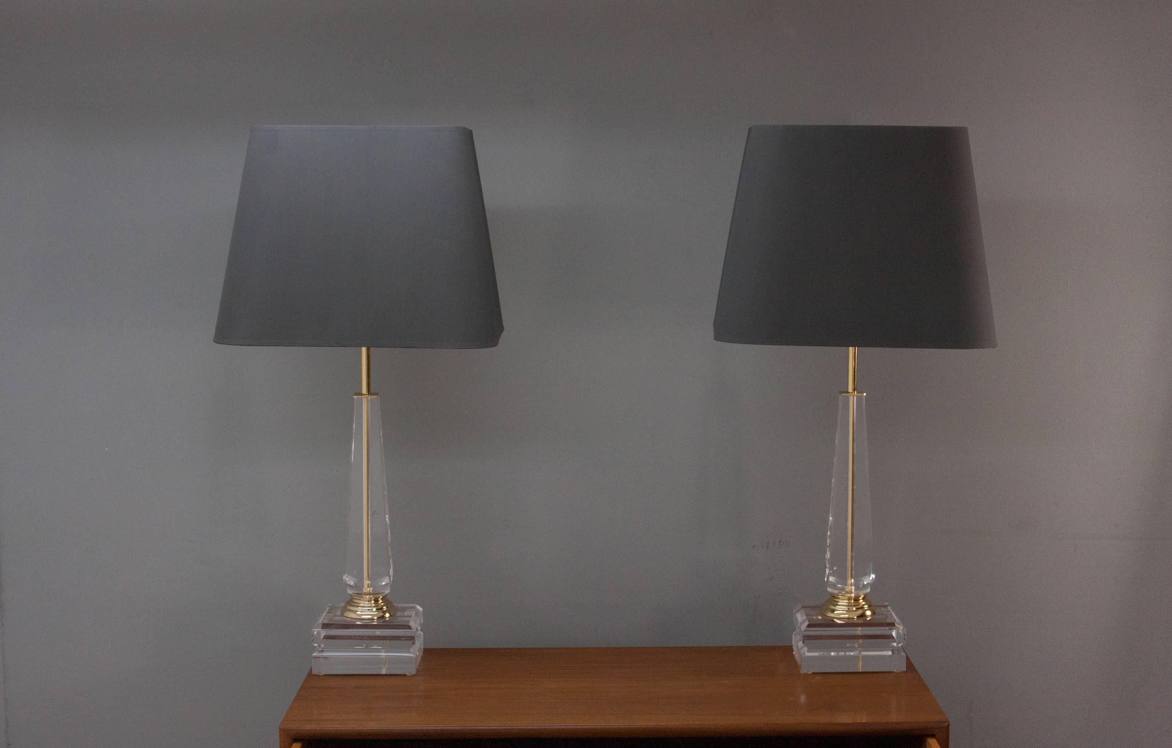 Two Hollywood Regency style acrylic and brass column table lamps.