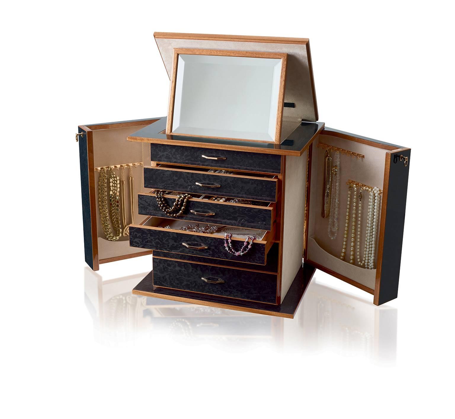Jewelry chest in polished black bird’s-eye maple and mahogany, ultra suede lining, 24-karat gold-plated brass accessories. With necklace bars, lockable doors and five drawers. Adjustable mirror on the top section.