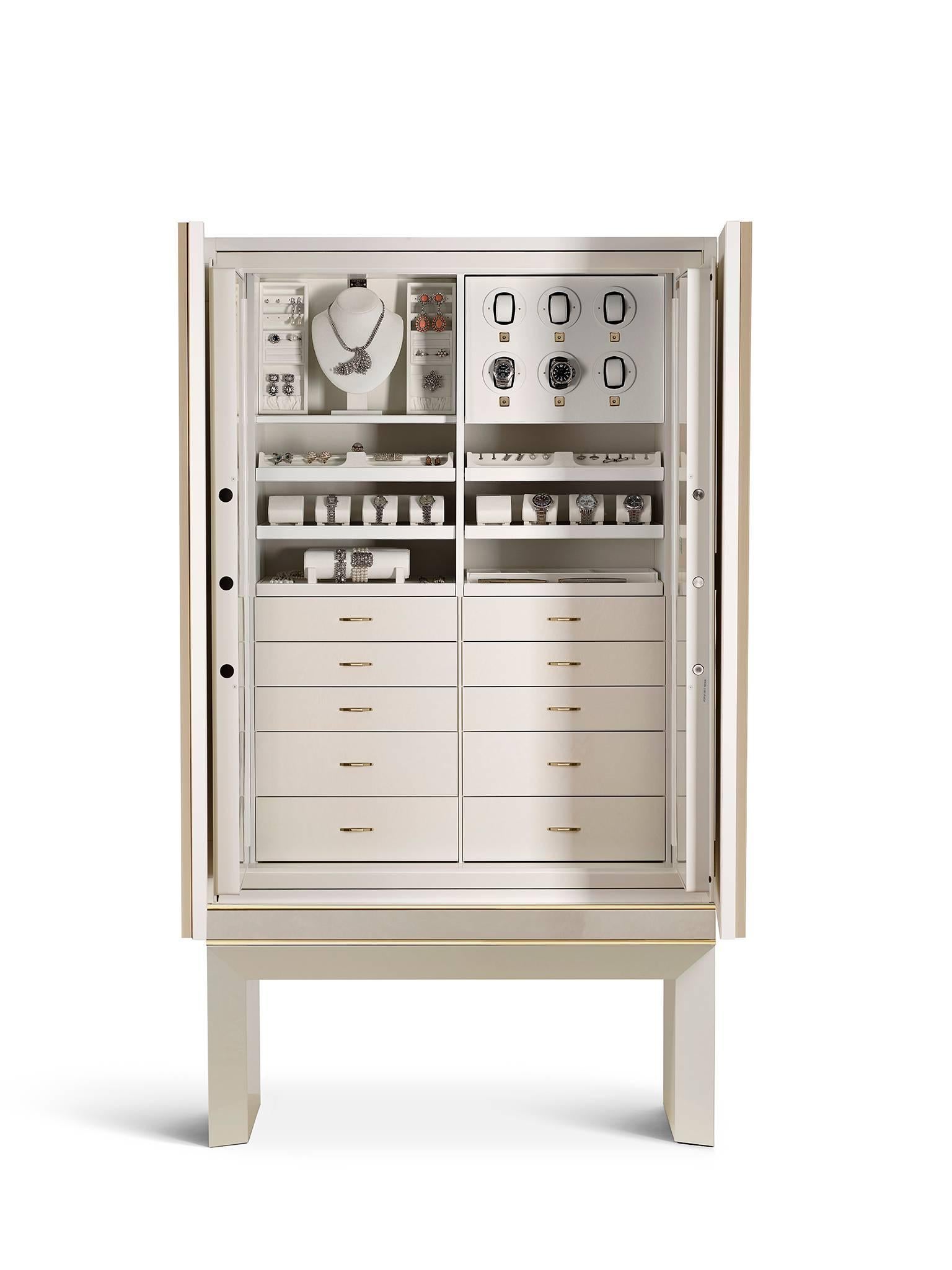Armoured jewelry armoire in polished white bird’s-eye maple and 24-karat gold hardware. Inside, safe with biometric opening device. Drawers and pull-out trays lined for jewelry. Six watch winders made in Switzerland and secret compartment.