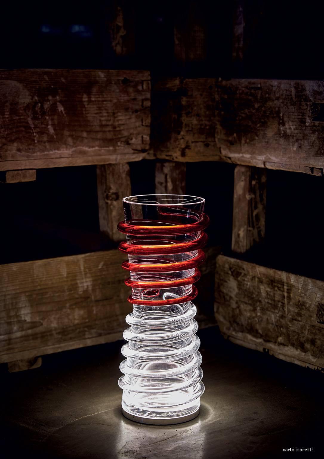 Lampe de table avec vase en verre de Murano soufflé à la bouche et fini à la main avec des éléments décoratifs. La base illumine le vase avec une lumière LED. La lampe a été conçue par Carlo Moretti en 2012.

2.lED à douille de 4 watts.


Carlo