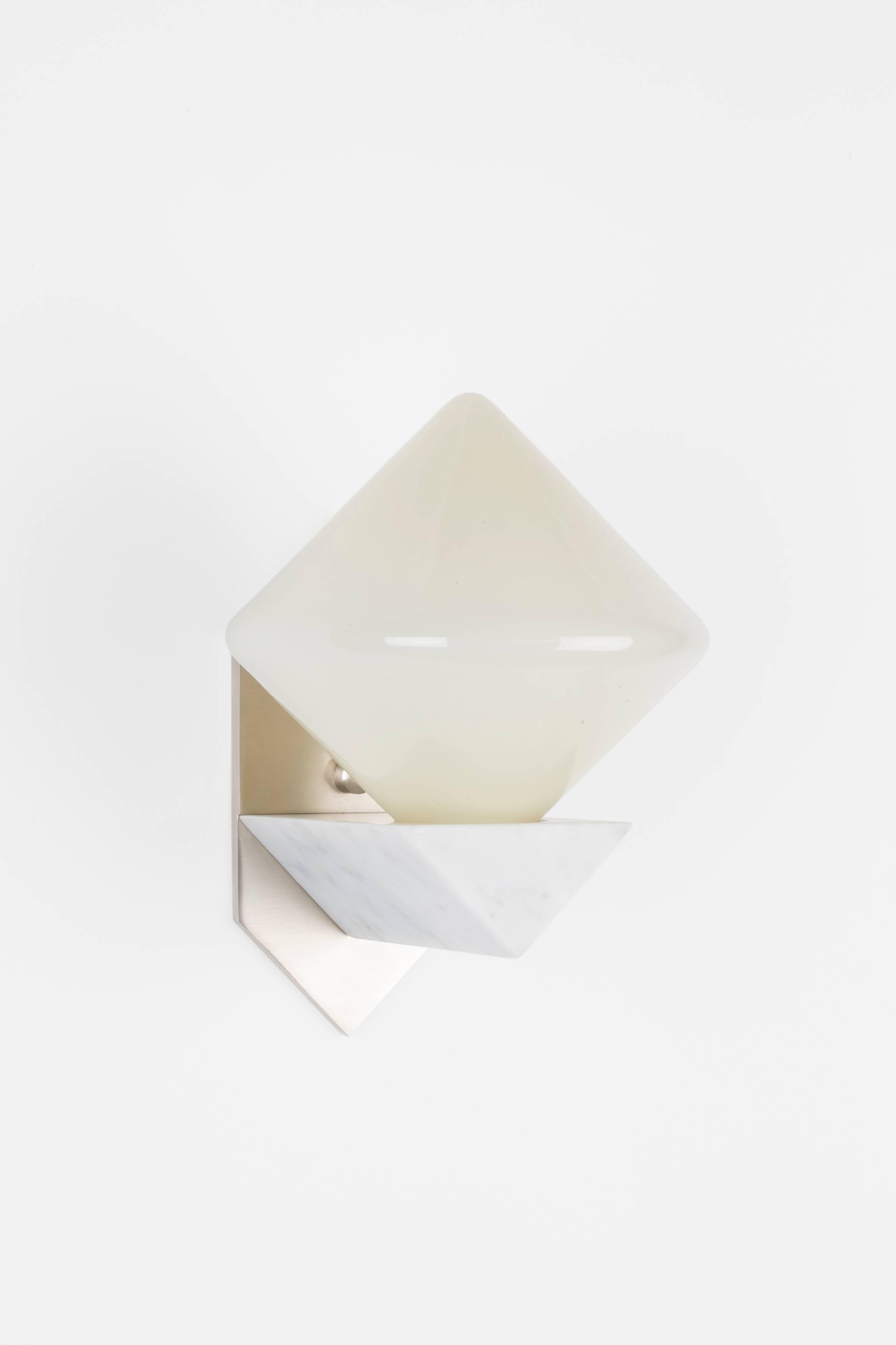 Originally inspired by Victorian balancing toys, Themis combines handblown glass diffusers with an elegant marble and brass bracket to provide a soft glow. The forms are derived from triangular forms manipulated through rotation, mirroring, and