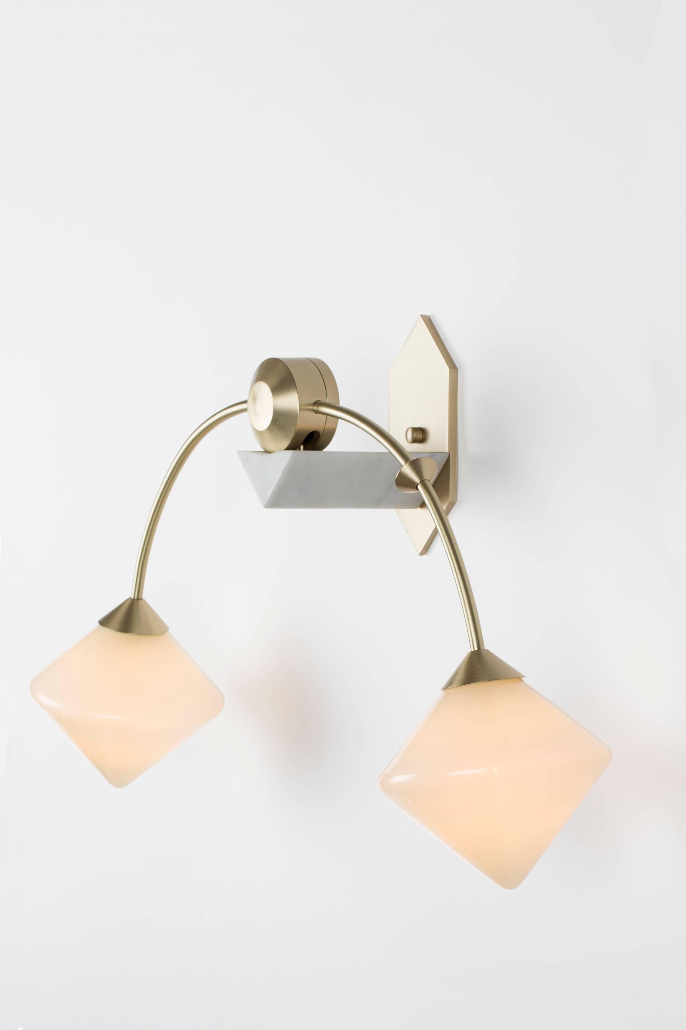 Originally inspired by Victorian balancing toys, Themis combines handblown glass diffusers with an elegant marble and brass bracket to provide a soft glow. The forms are derived from triangular forms manipulated through rotation, mirroring, and