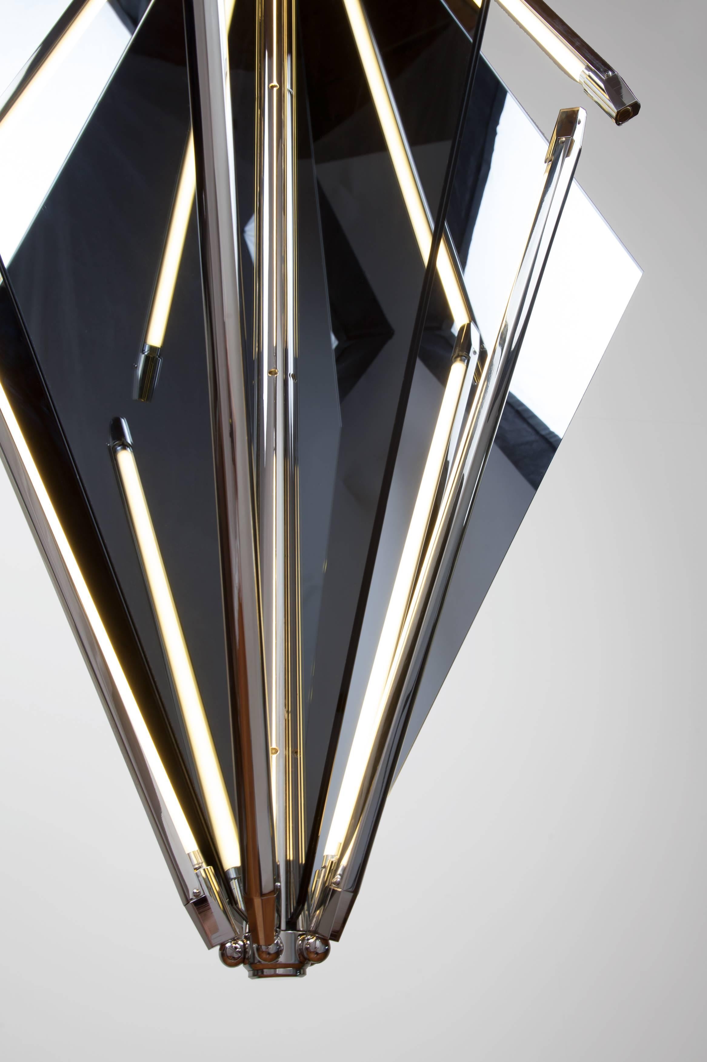 Echo uses fins of mirror radiating from a central axis to reflect beams of light. LED tubes are turned inward to bounce off the glass the light becomes both softened and multiplied. Also available with fins of glass which diffuse the light and