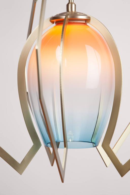 Vise captures a handblown glass globe within brass claws machined to follow the gentle curvature of the glass. The illumination is set high inside the globe, creating a soft glow that gradually fades towards the opening. Shown here in in special