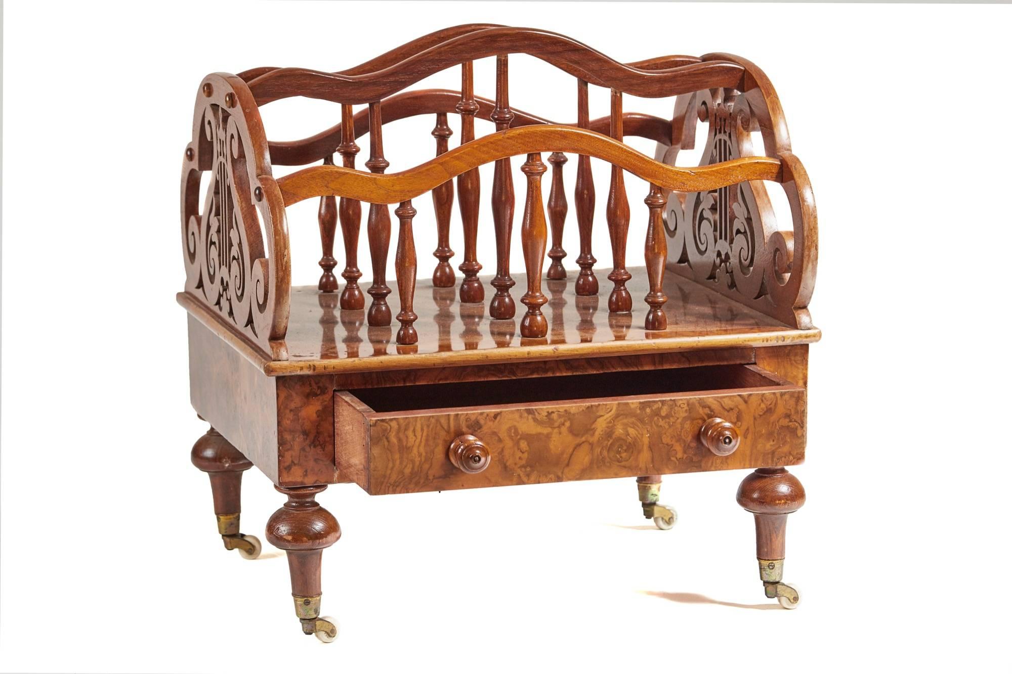 A burr walnut Victorian Canterbury, having unusual pierced fretwork sides, the internal divisions are made from solid walnut turnings, above are nice shaped solid rails, the base is veneered in burr walnut having a drawer with original walnut knobs,