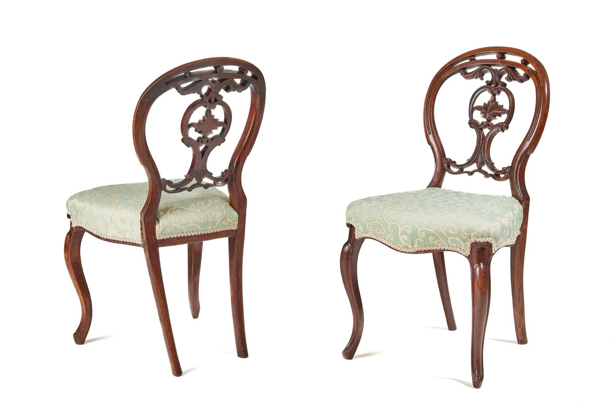 An elegant set of six Victorian walnut dining chairs, the balloon back having a nice carved centre, the seats are serpentine fronted and rest on a cabriole leg, the back legs are outswept these chairs have been newly re-upholstered.