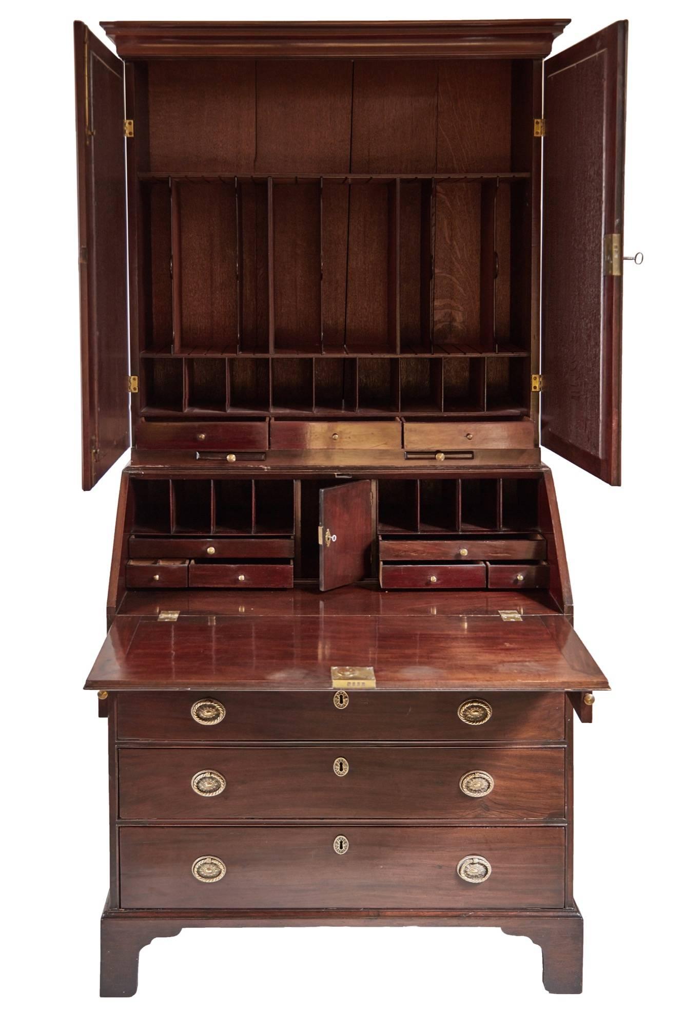 Georgian mahogany bureau bookcase, the top section has an ogee shaped cornice, the bookcase with original mirror plates enclosing a fitted interior with drawers and adjustable shelves, two candle slides under the mirrors, the bureau has original