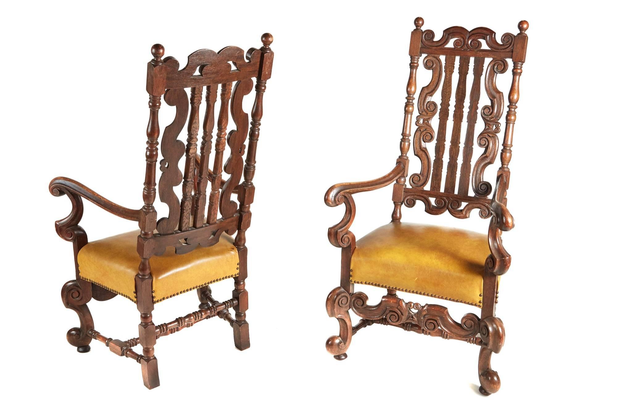 A large pair of Charles II style oak armchairs, with pierced scroll form and slatted backs between turned uprights, down swept arms and scrolling under tier, on short cabriole legs, overstuffed with leather upholstered seats.

Lovely colour and