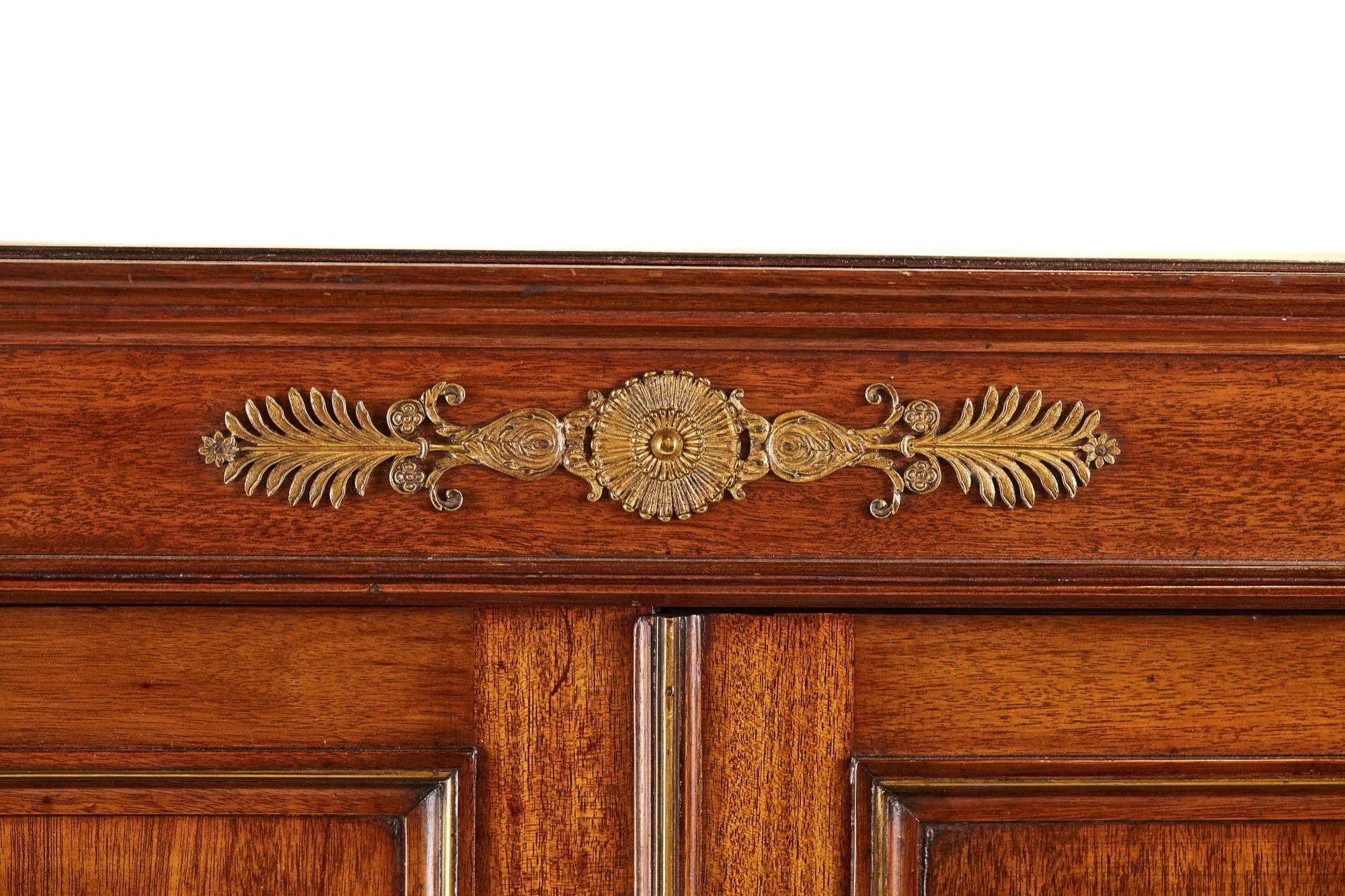 A French Empire mahogany and gilt metal mounted cabinet on chest, the upper tier with two cupboard doors fitted with gilt metal mounts, the chest below with three short drawers and two long drawers with gilt metal mounts and handles, standing on