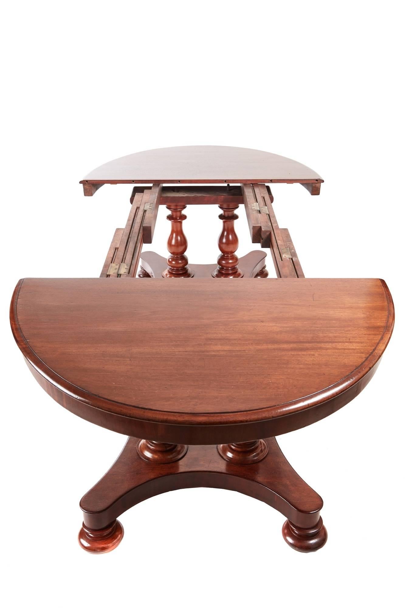 19th century mahogany extending pedestal dining table, with moulded edge top, two additional leaves and plain apron, the base with four turned columns on a platform base that splits open with bun feet below and concealed castors under those,
a rare