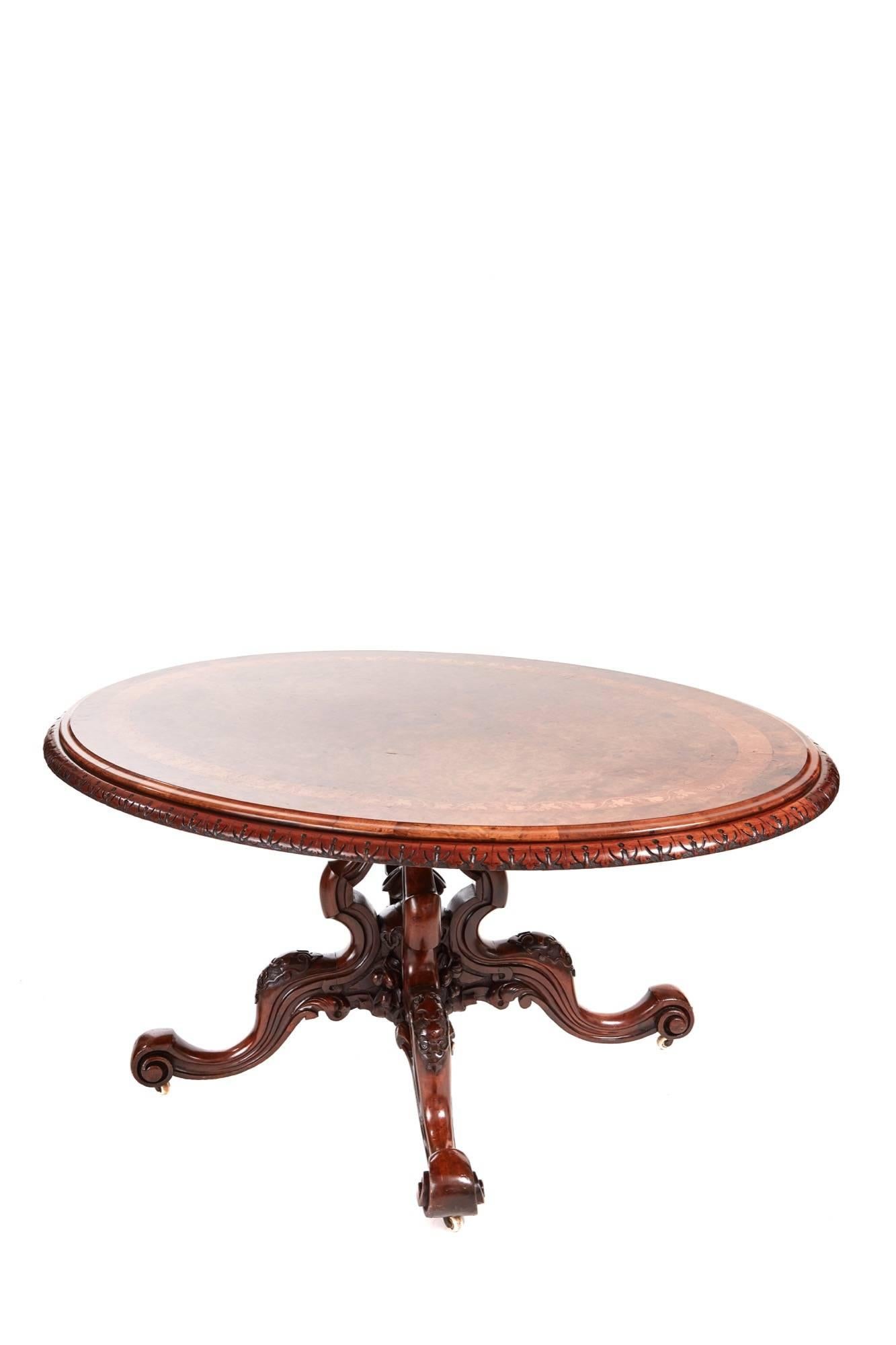A fine quality Victorian inlaid burr walnut centre table, the oval top inlaid with kingwood and satinwood marquetry banding thumb moulded edge and a further carved edge, standing on a fantastic carved shaped basket base lovely carved final to the