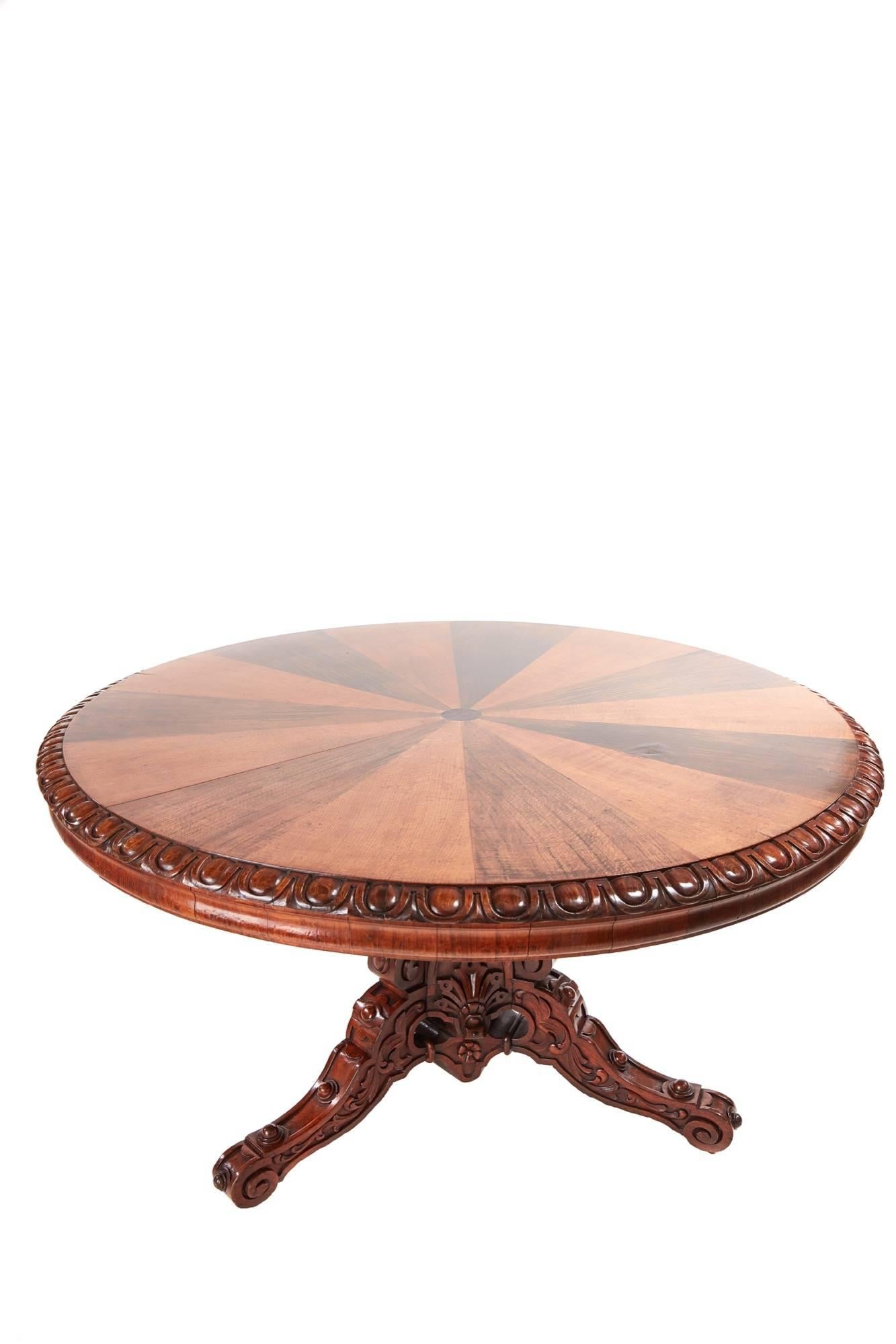 A rare specimen centre table, a large round Victorian specimen centre table with segmented oak and walnut top, lovely carved edge, unusual shaped apron, raised on a decoratively carved oak and walnut triform base with carved pedestal and three