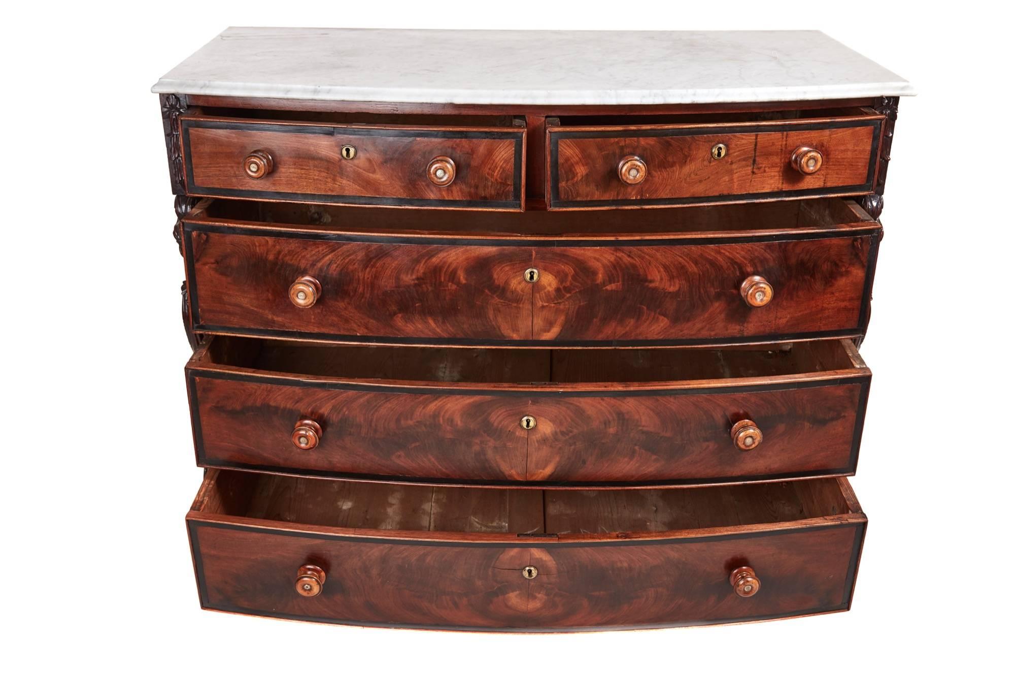Unusual antique mahogany bow front chest, with a white marble top, thumb moulded edge, two short and three drawers long drawers in figured mahogany crossbanded in ebony, with original turned knobs, standing on turned feet.
Lovely color and