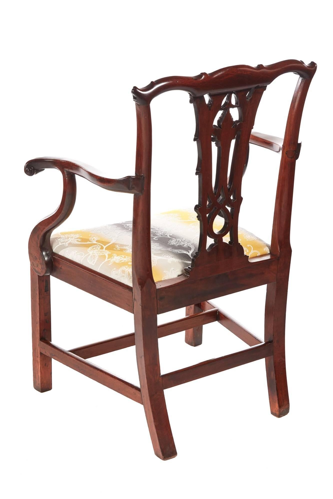 George III mahogany elbow/desk chair, with a shaped carved top rail and open lattice work splat, shaped open arms, newly recovered drop in seat, standing on square moulded legs to the front outswept back legs united by four stretchers
Lovely color