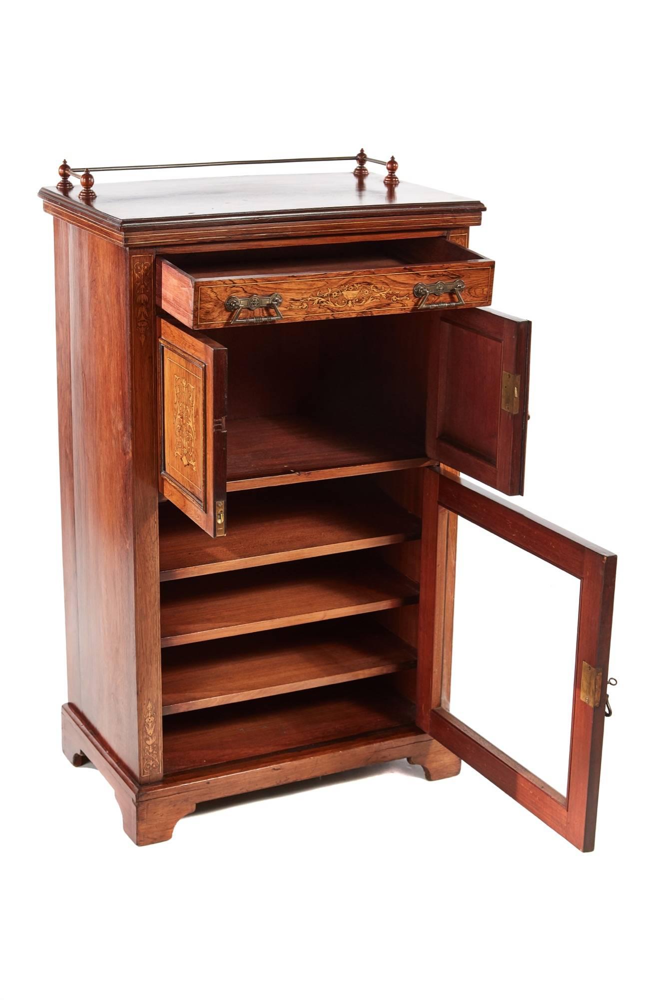 Good quality rosewood inlaid music cabinet, having a brass gallery, lovely inlaid rosewood top, one inlaid drawer with original brass handles, two inlaid doors and one glazed door original brass handles, standing on a shaped plinth base, original