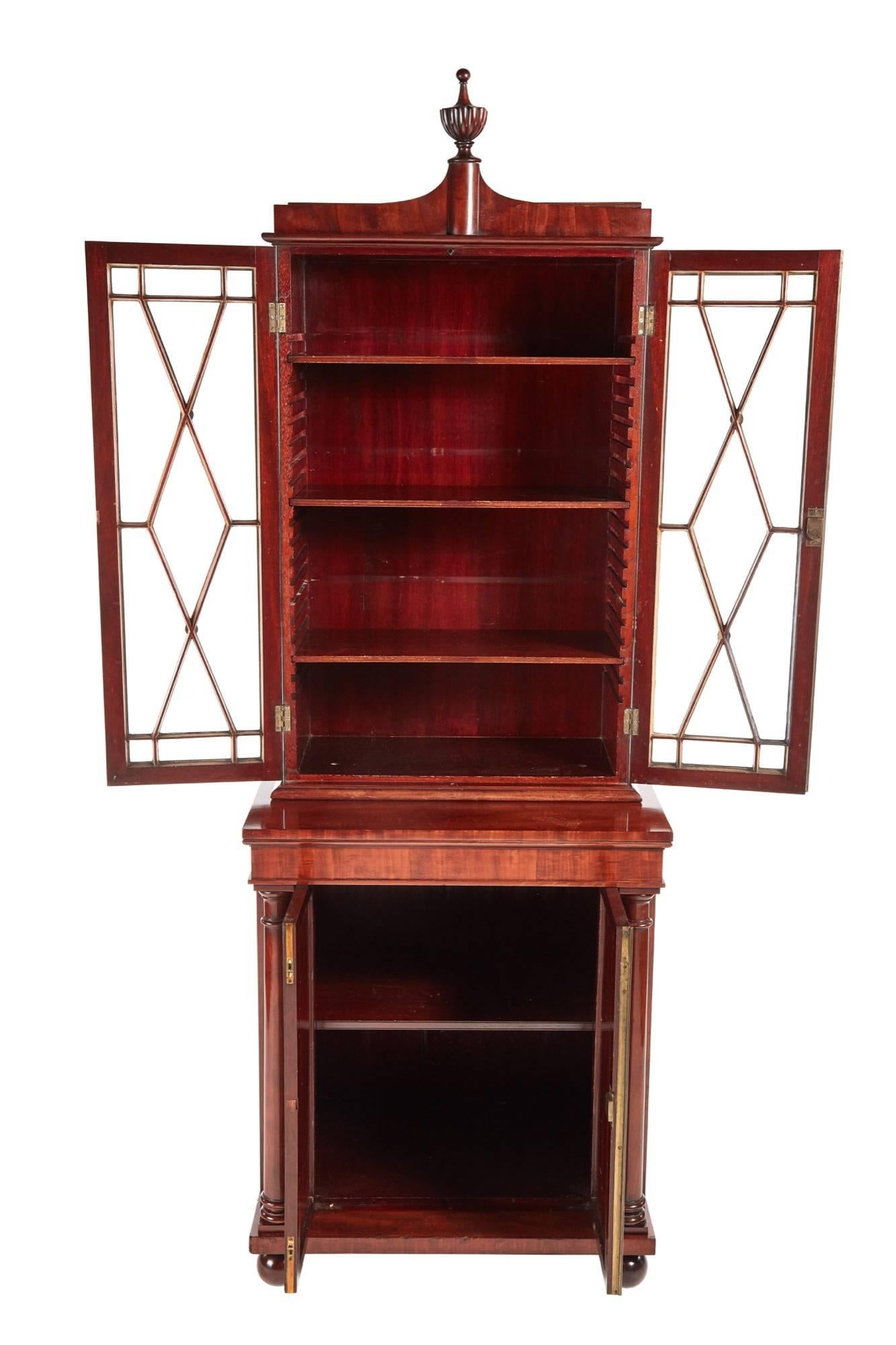 Fantastic quality William IV mahogany bookcase, the upper section with a shaped reeded urn, over a shaped cornice, pair of astragal glazed doors open to reveal an interior with adjustable shelves, the base having a mahogany top, two figures mahogany