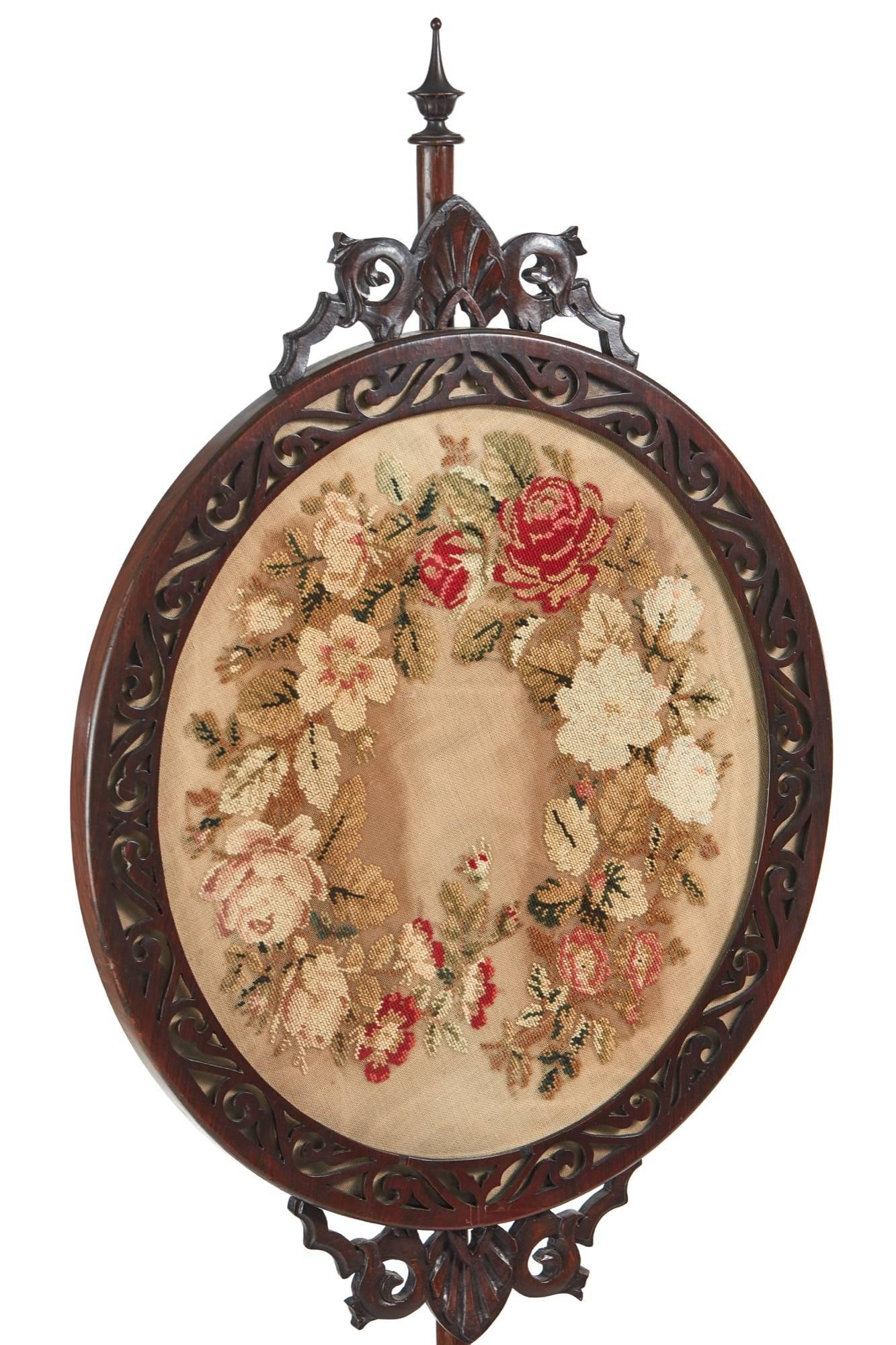 Victorian walnut adjustable pole screen, with a screen featuring a walnut fretwork frame, original gros-point oval tapestry supported by a walnut pole, standing on a lovely carved base with shaped carved cabriole legs
Lovely color and
