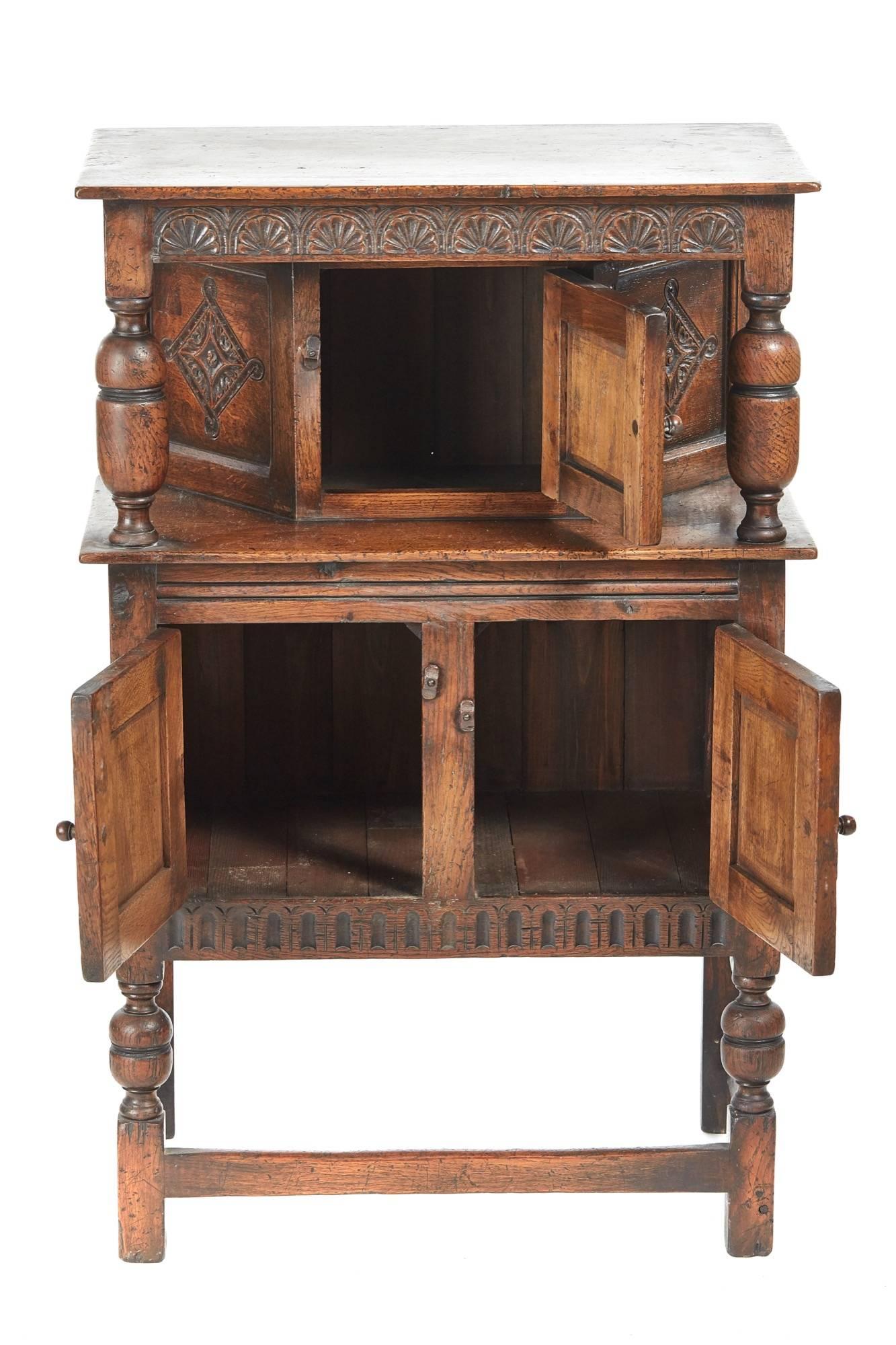 Small antique carved oak count cupboard, in the Jacobean style, the top section with a carved frieze, carved centre door and carved panels and turned bulbous, the base with two carved doors, carved frieze, standing on turned bulbous legs, original