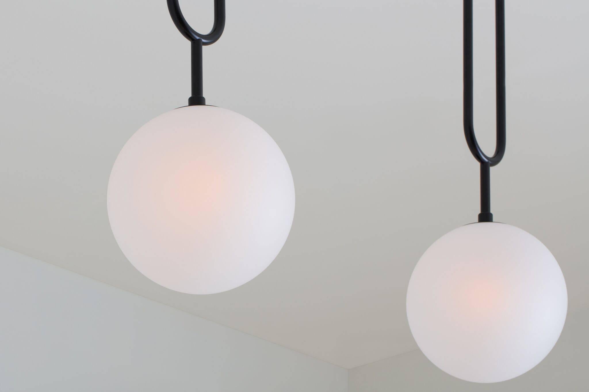 Drawing inspiration from a pearl pendant, the Koko line is elegant and modern, with its luminous blown glass and brass arch detail. A versatile light, Koko can be displayed as a single pendant or arranged in a grouping as a