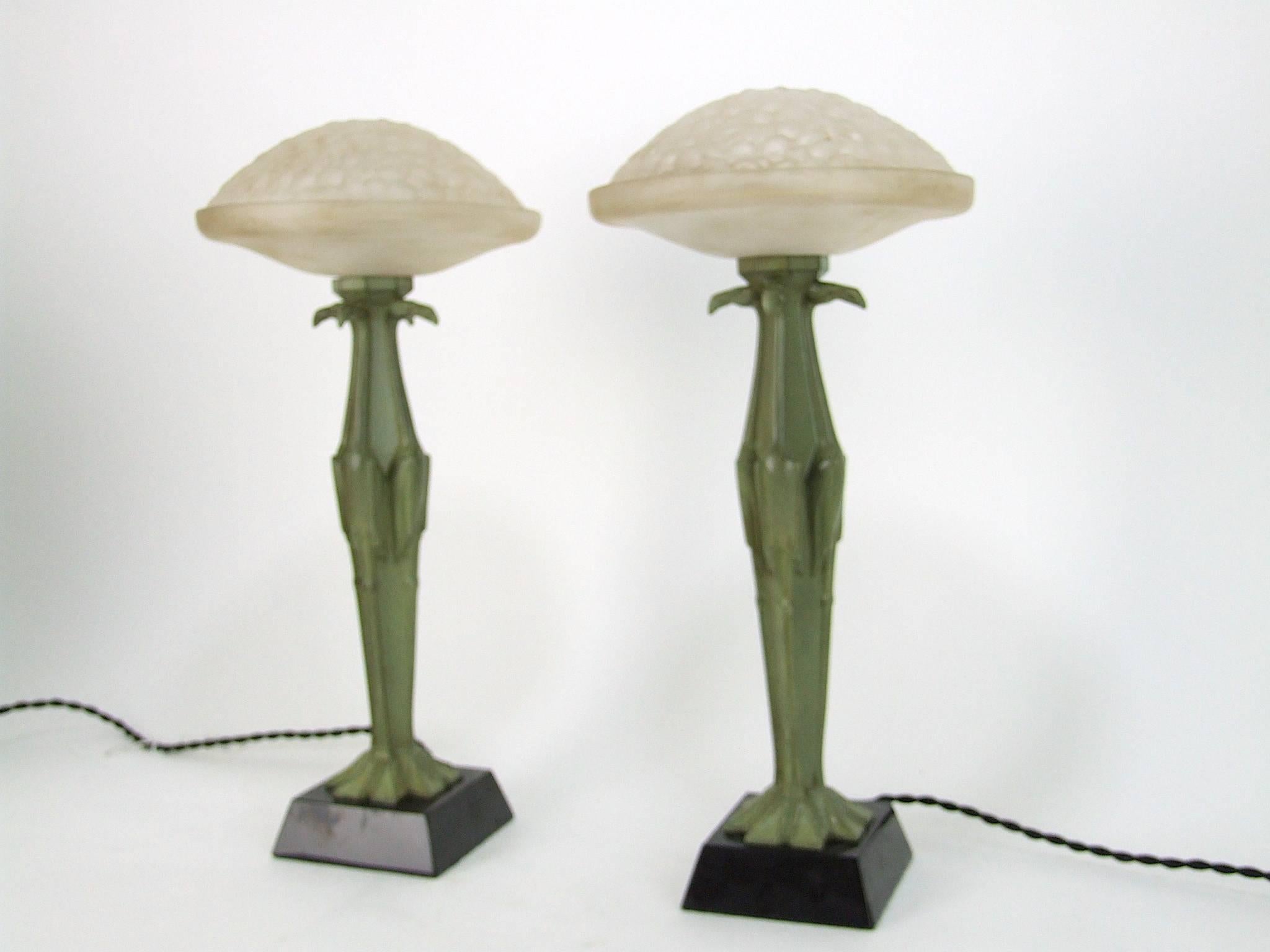A pair of original French Art Deco cubist flamingo table lamps in green patinated spelter by Max Le Verrier. Stamped to the base metal Le Verrier and stamped with the foundry stamp. The glass shades are in two parts, the bottom part is fixed to the