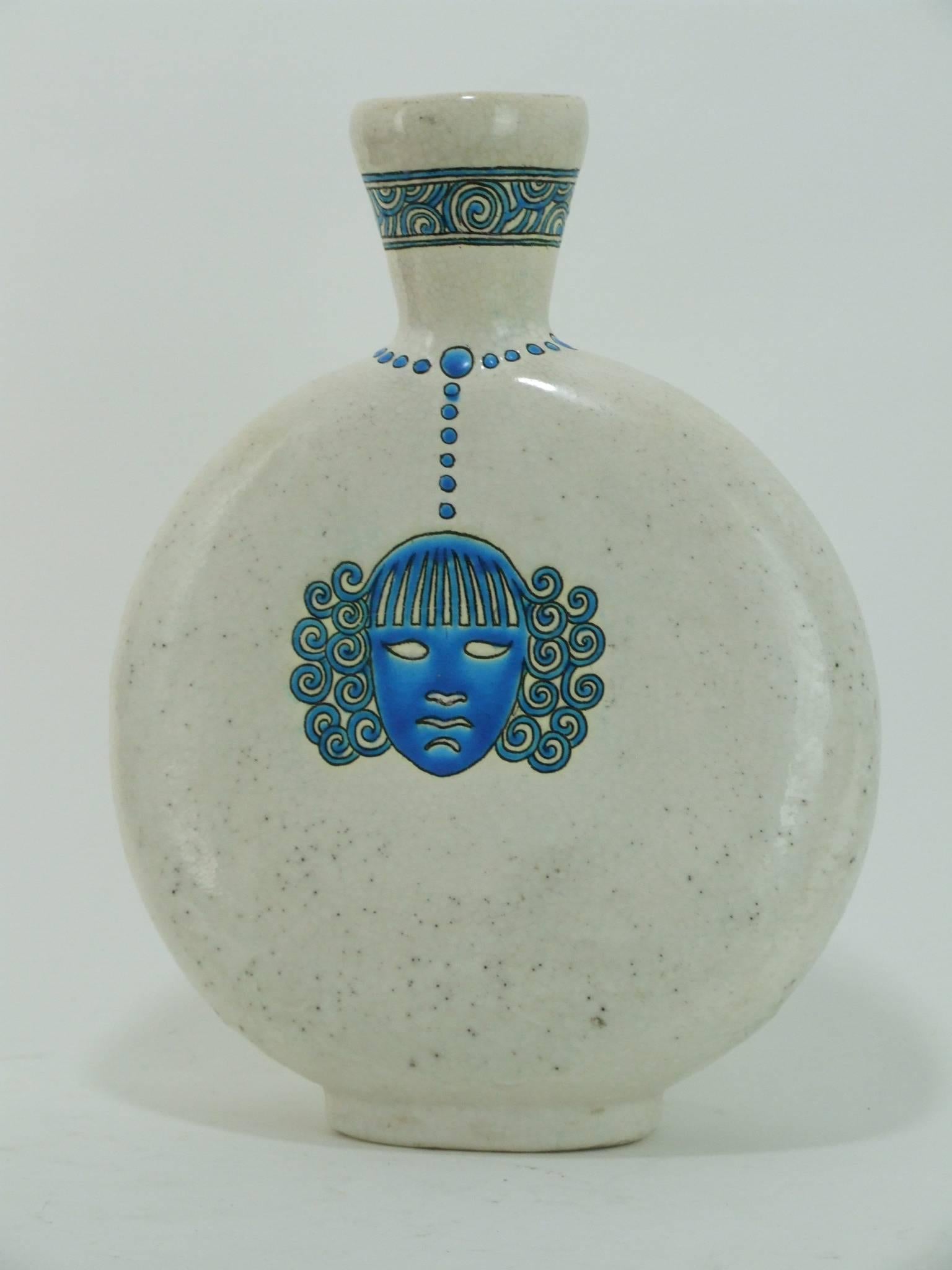 A flat crackle glaze French ceramic vase of flat rounded form with blue glaze face detail to both sides. Marked to the base with the Longwy, France stamp. It measures 12 inches (30cm) high and 9 inches (23cm) wide. Very good original condition.