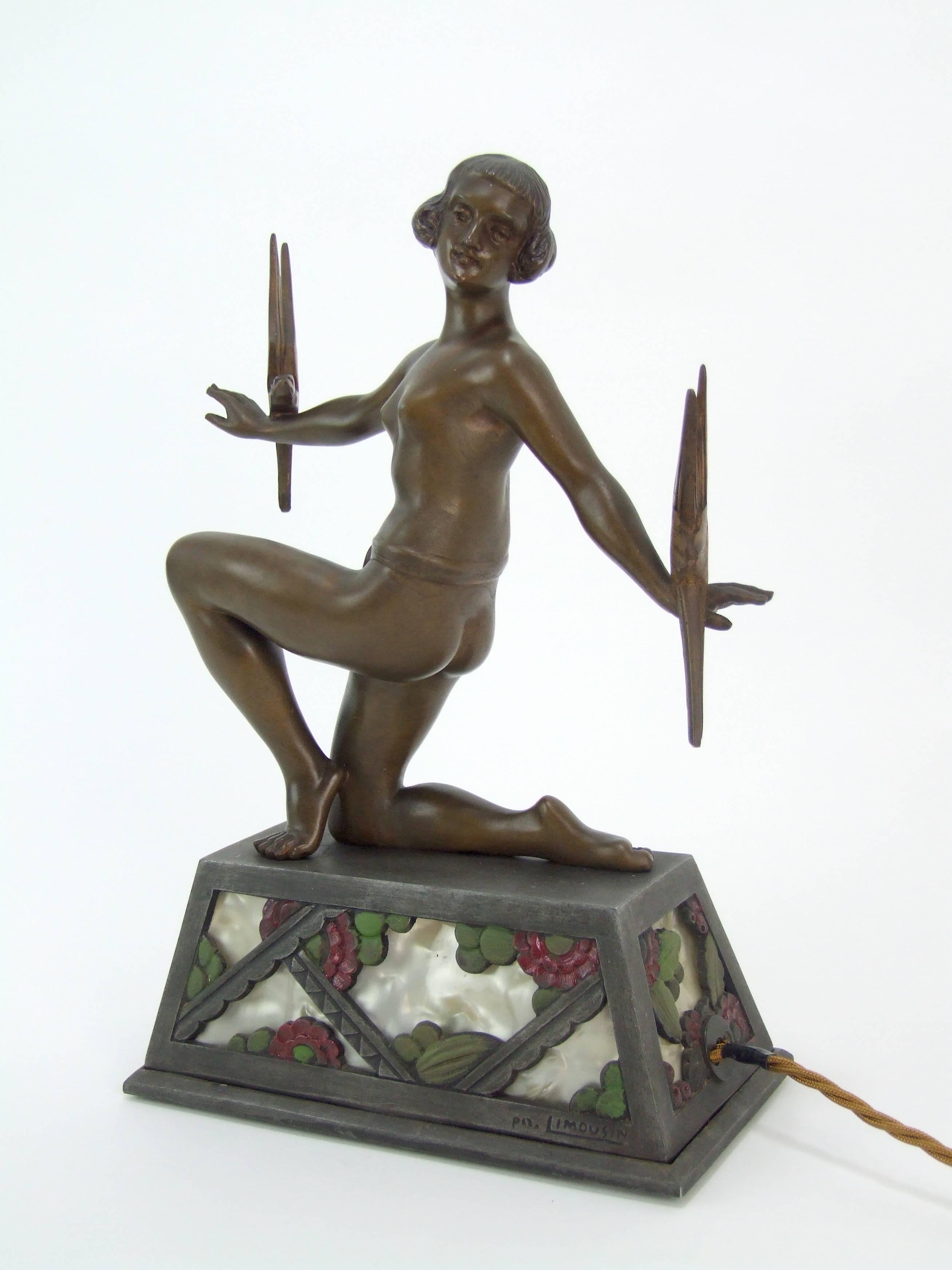 French spelter Art Deco lady lamp - a signed piece by Limousin (signed to the light-up base). Hand-painted stylized floral details with phenolic panelling to the base which lights up. It measures 8 inches wide by 4 inches deep and 12 inches high