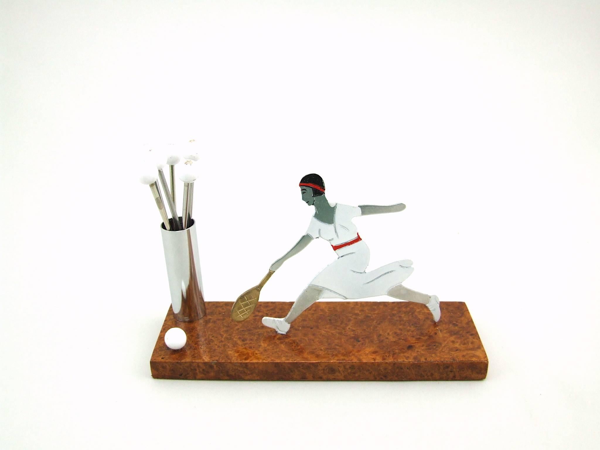French Art Deco cocktail sticks set, modelled as Suzanne Lenglen the 1920s French tennis champion. Mounted on an amboyne wooden base that measures 6 inches long and total height is 4 inches (15cm x 10cm). In excellent vintage condition. An unsigned
