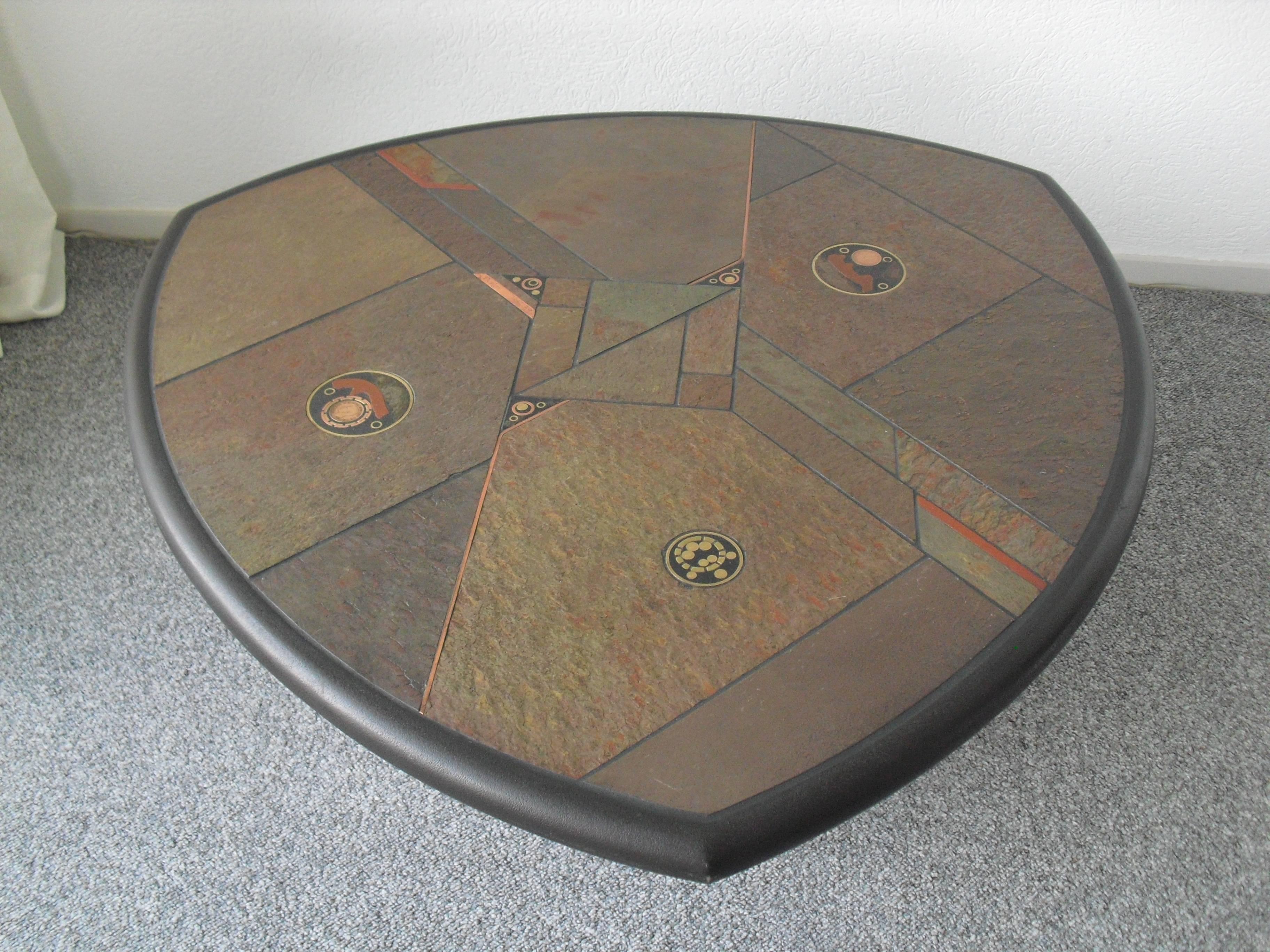 This multicolored slate and stone coffee table with copper and brass details is made by Fedam Belgium during the 1980s.
Surprising rounded triangle shape!