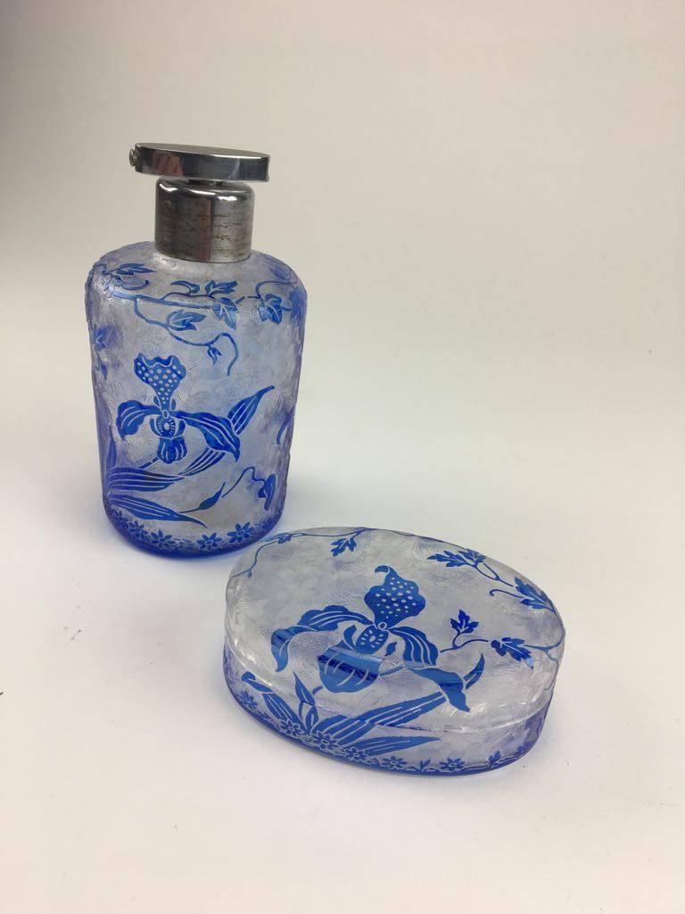 This rare cameo glass perfume set was made by Val Saint Lambert Belgium between 1900 and 1920.

Cameo glass is a luxury form of glass art produced by etching and carving through fused layers of differently colored glass to produce designs.
This