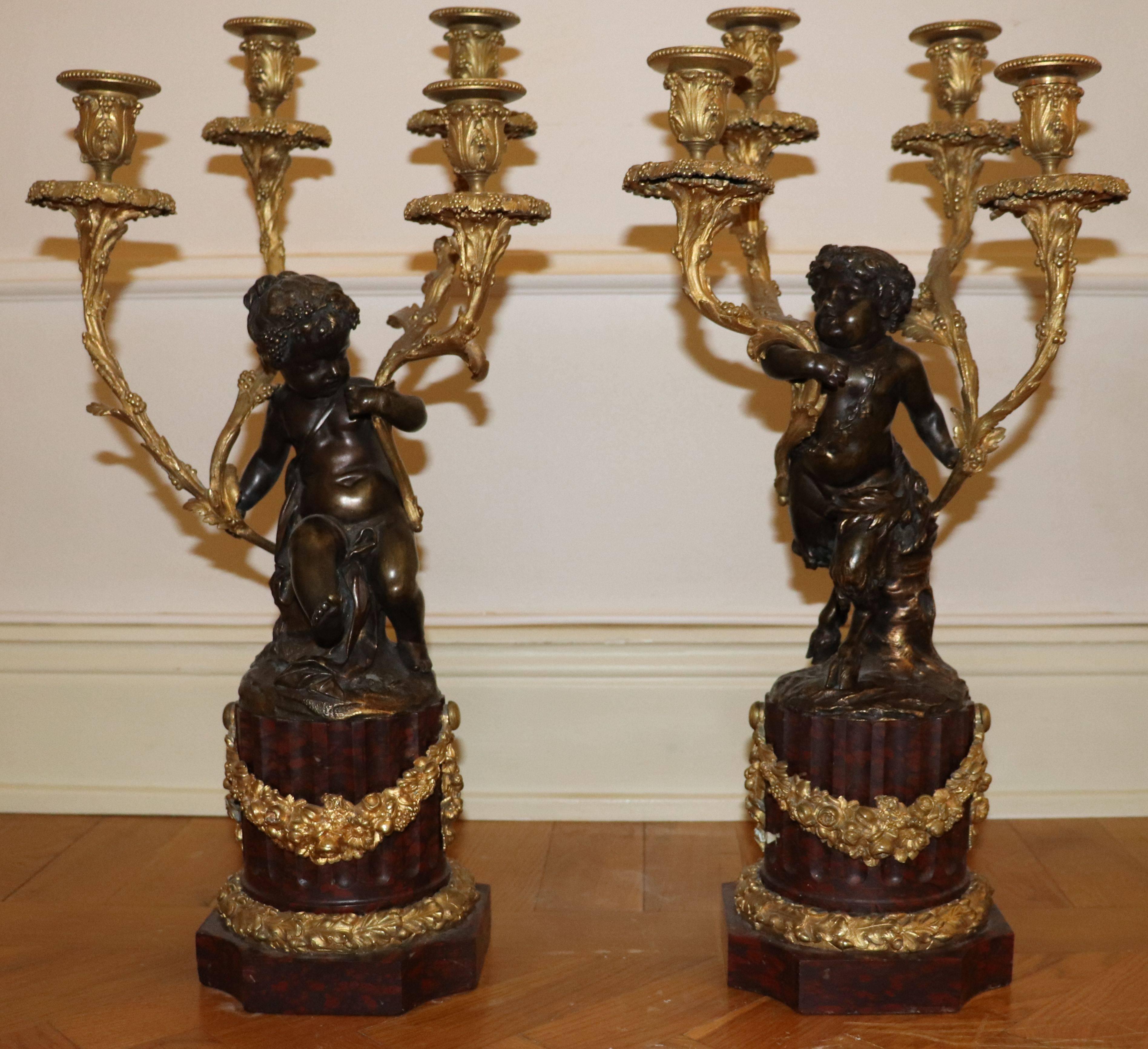 A pair of Louis XVI gilt bronze and patinated candelabra attributed Jean-Louis Prieur
depicting one female cherub and one male satyr cherub holding four candle arms/holders each.