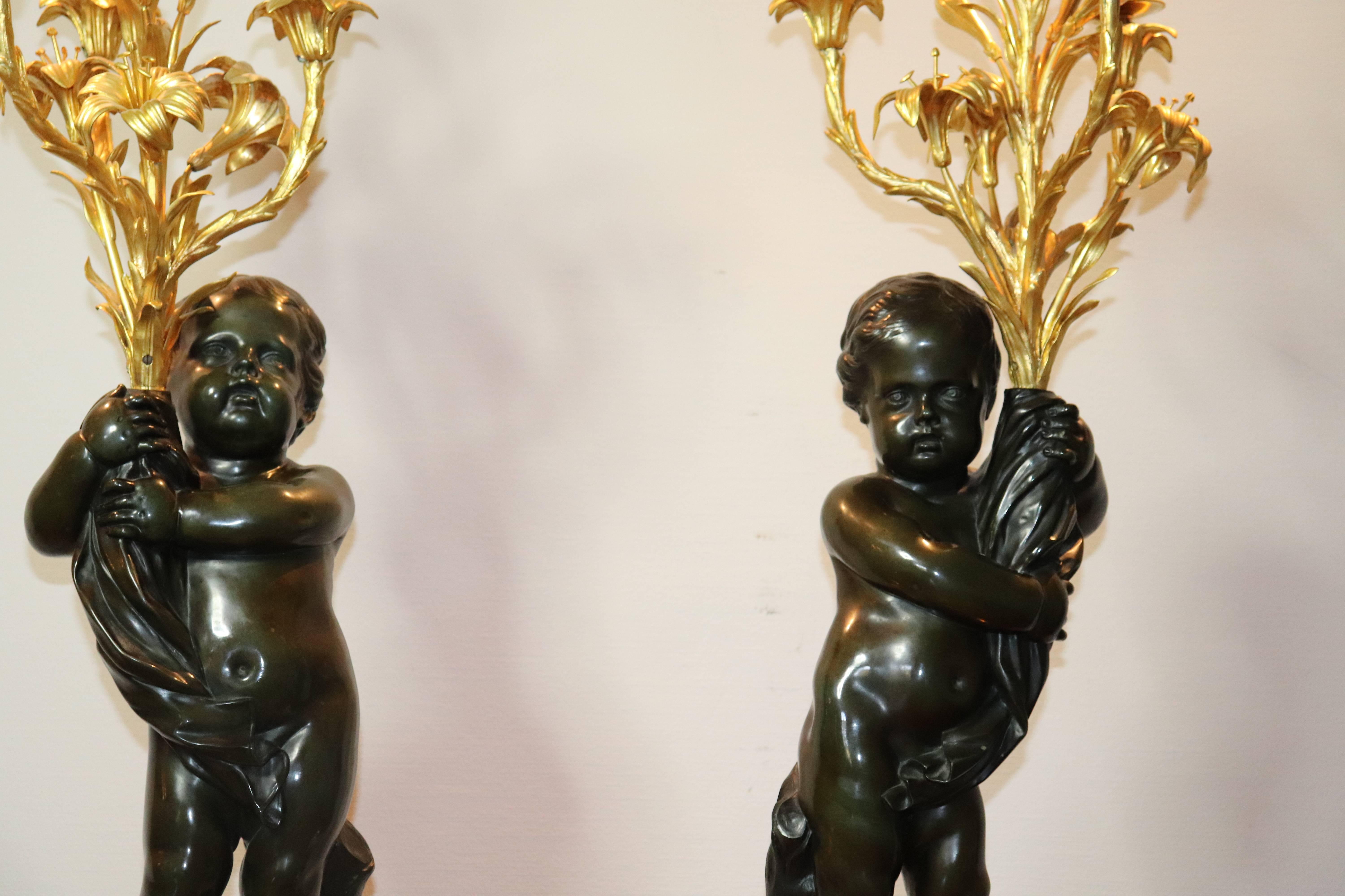 pair of Large French Louis XVI gilt and patinated bronze candelabra attributed to Claude Michel Clodion (1738-1814)
depicting Putto Figures holding arms with four candleholders on each, measure: 109 cm height.