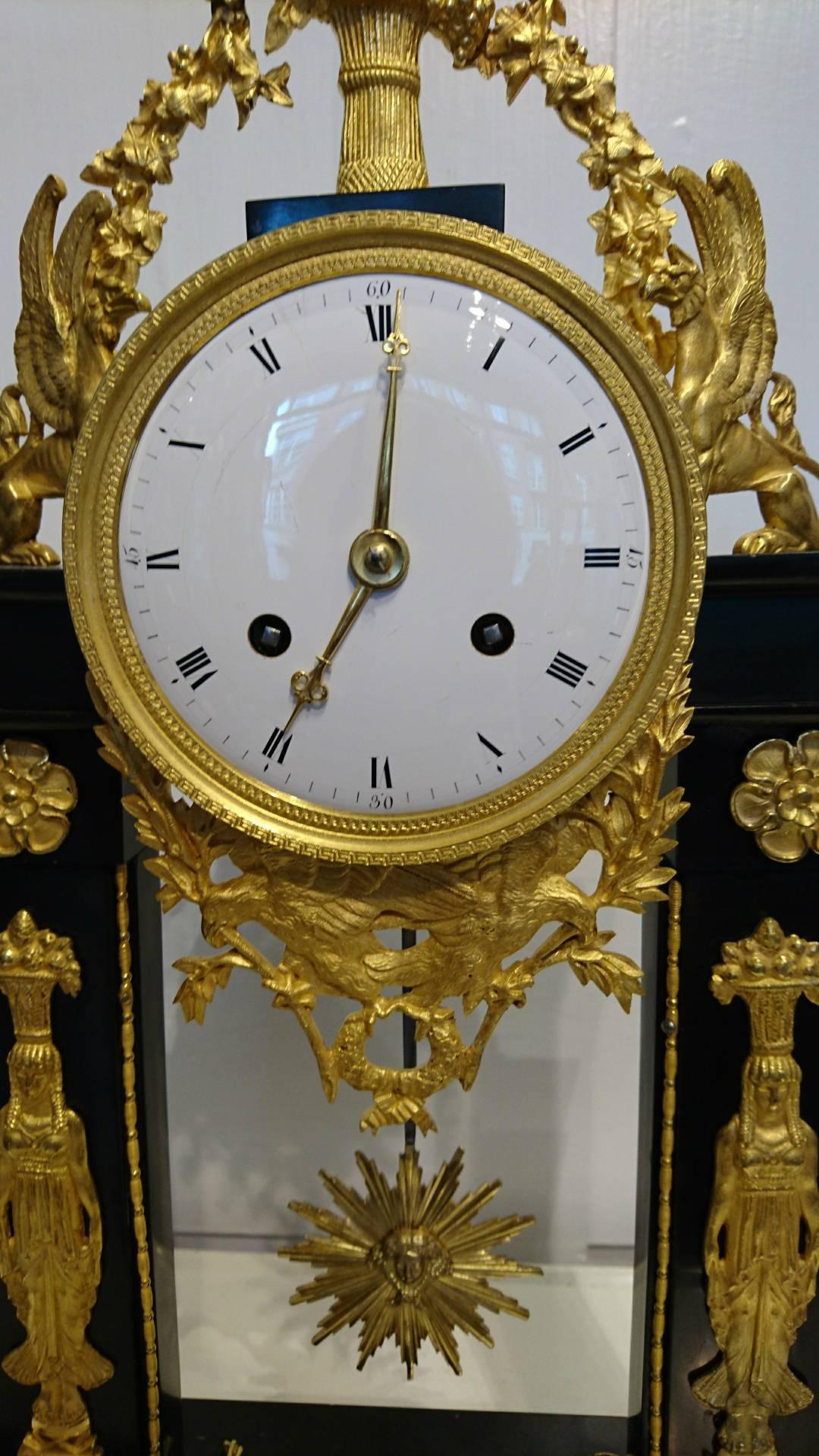 First Empire French portico clock, circa 1800.

This stunning early 19th century clock is an excellent example of the portico genre clocks of the Empire period. The high grade silk suspension movement, striking hours and half hours on a