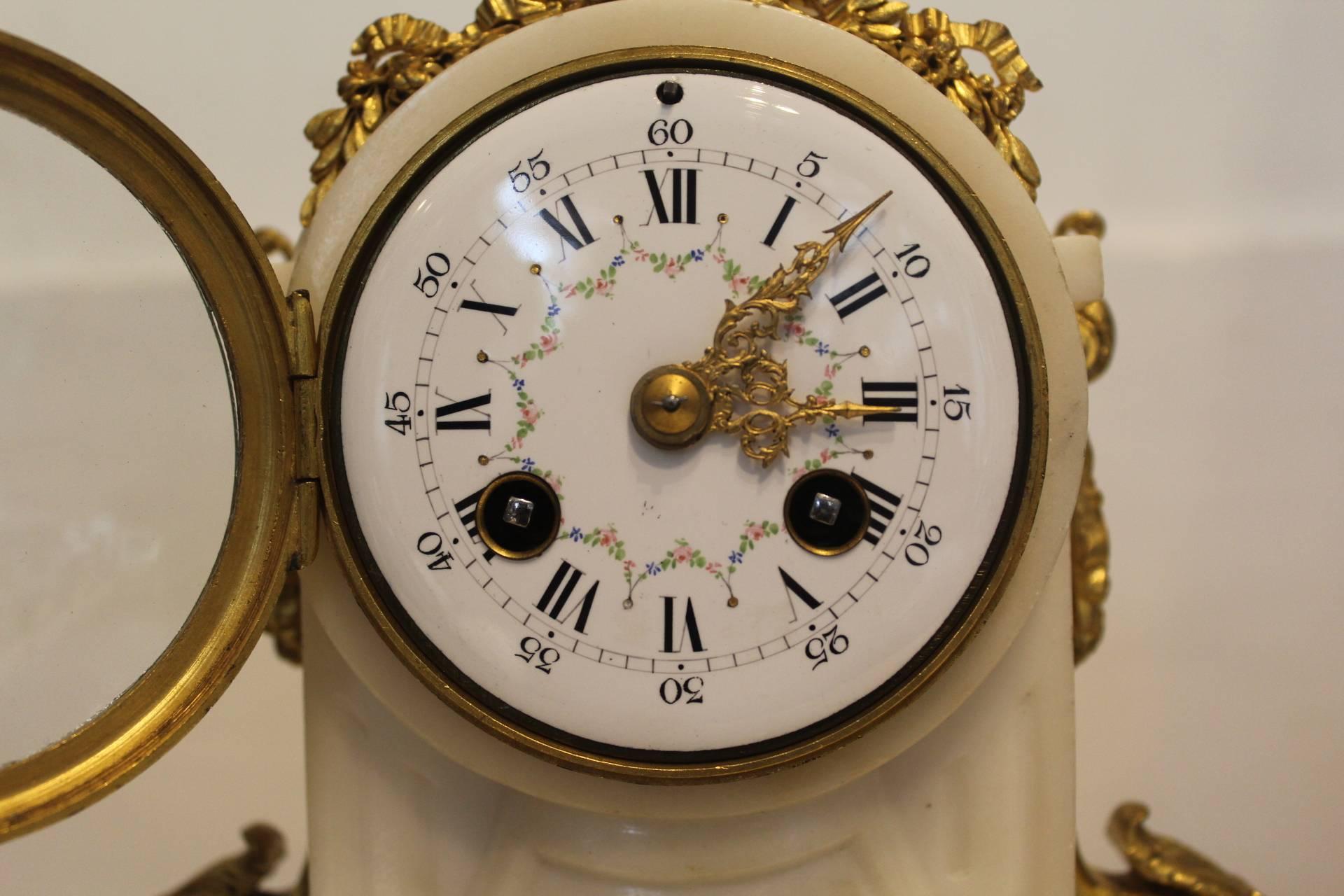 
French, white marble garniture with decorative ormolu mounts, circa 1890.

This elegant French garniture/clock set has an eight-day movement de Paris, which will strike both hours and half hours on a bell. The movement is stamped by the maker,