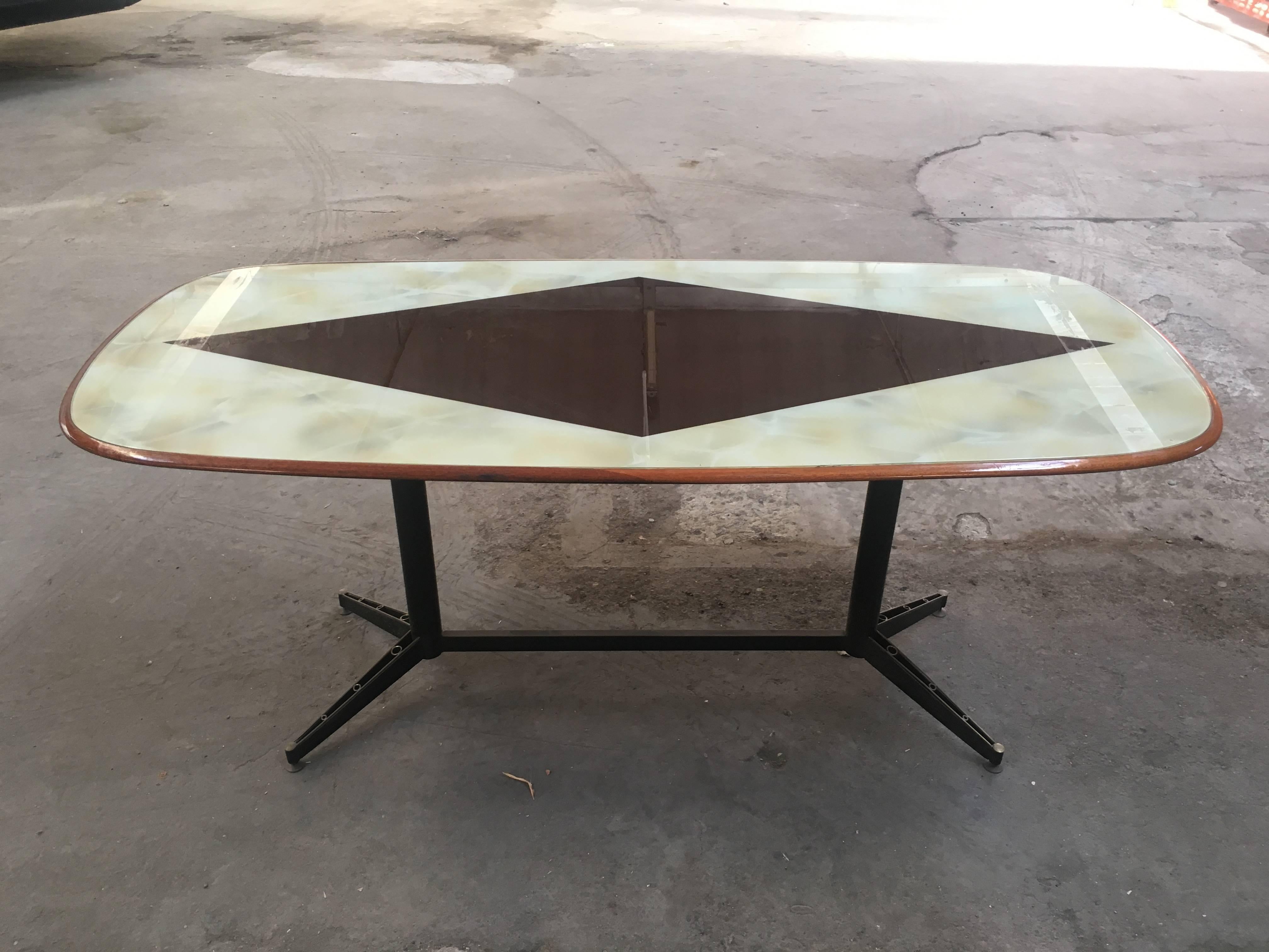 Italian dining or center table from 1960s. Black iron basement with brass feet and marble painting geometrical motive on the top.