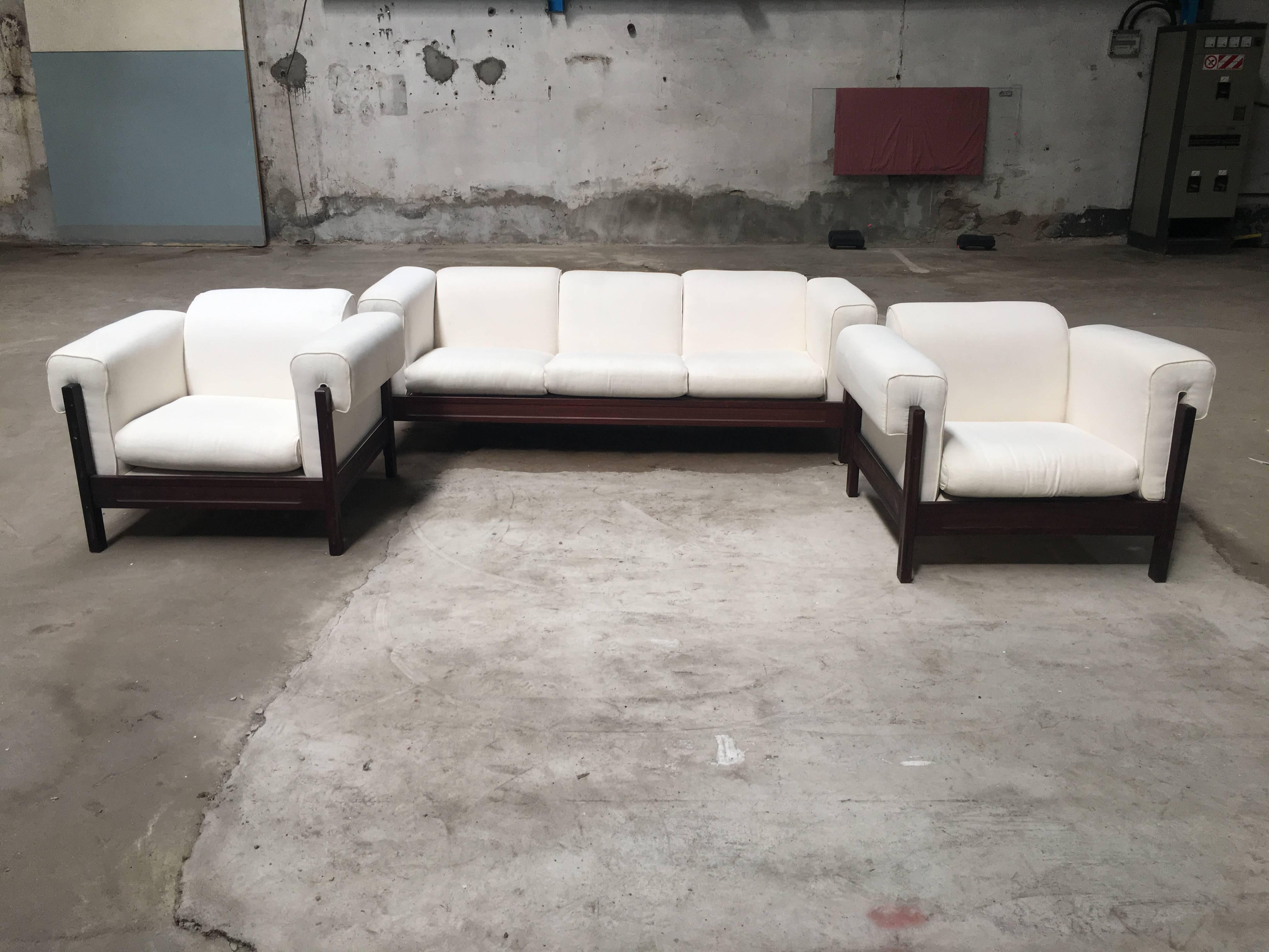 Mid-Century Modern Italian set composed of a three-seat sofa and a pair of armchairs. 
The structure of this set is in hard mahogany wood.
The set is in perfect conditions with its original vintage white cushions.

Measurements:
Sofa: Width