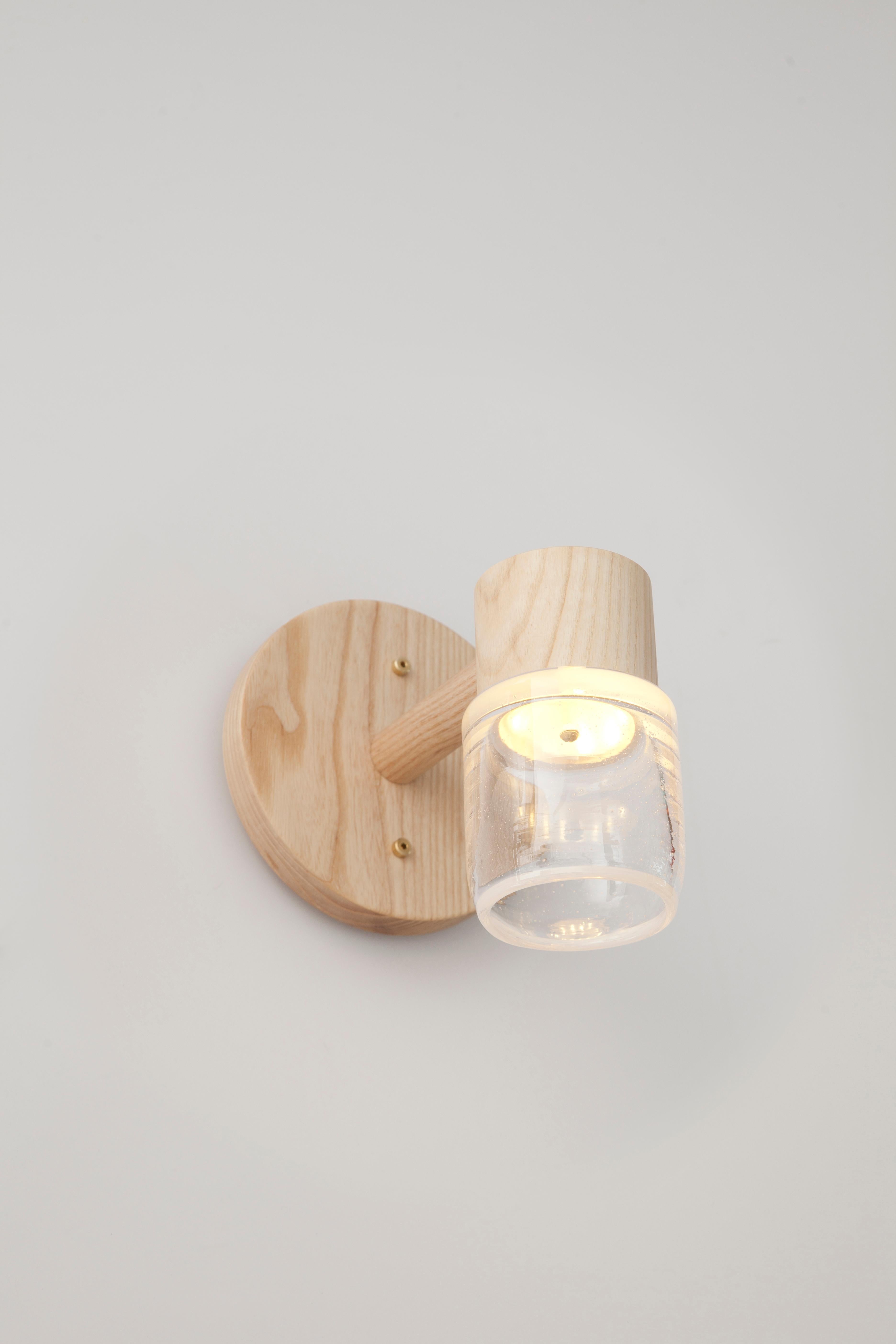 This handmade sconce pairs a minimal solid wood canopy with a hand blown glass diffuser. Efficient LED lighting components are neatly hidden in each canopy allowing the glass diffuser to illuminate without a visible bulb. 

Built in the Pacific