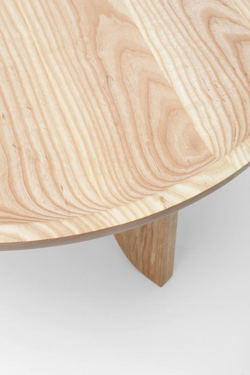 Taking inspiration from hand-carved African stools, a scooped out tabletop is created with a little help from technology. A CNC router is used to cut away the wood bowl leaving behind a slope that quickly levels to a flat surface.

Built in the USA