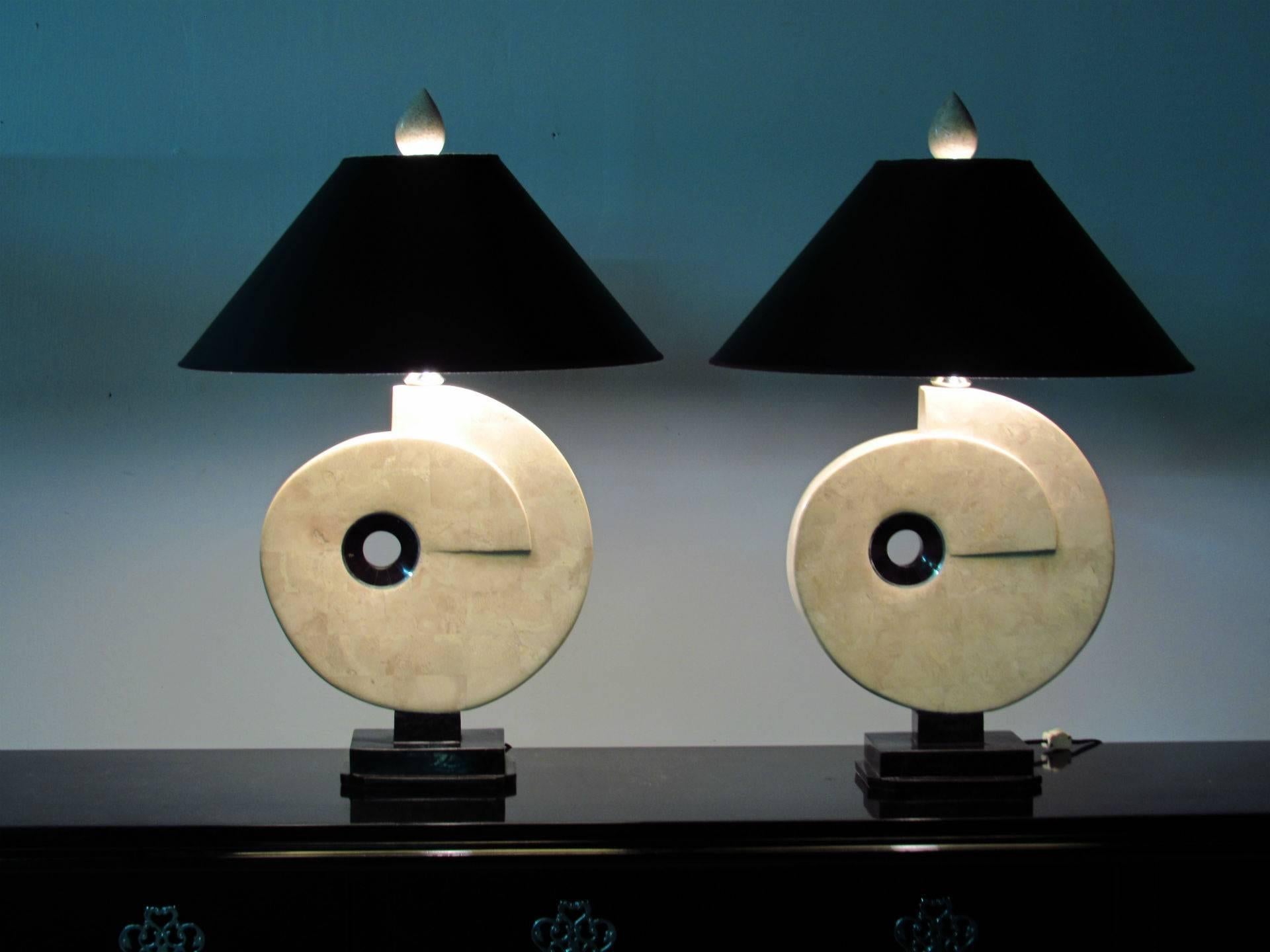 Beautifully crafted pair of table lamps in the shape of large Nautilus shells made of tessellated fossil stone pieces, back tessellated marble centers and polished nickel hardware.  Each lamp sits on a polished black marble bases and is topped by a