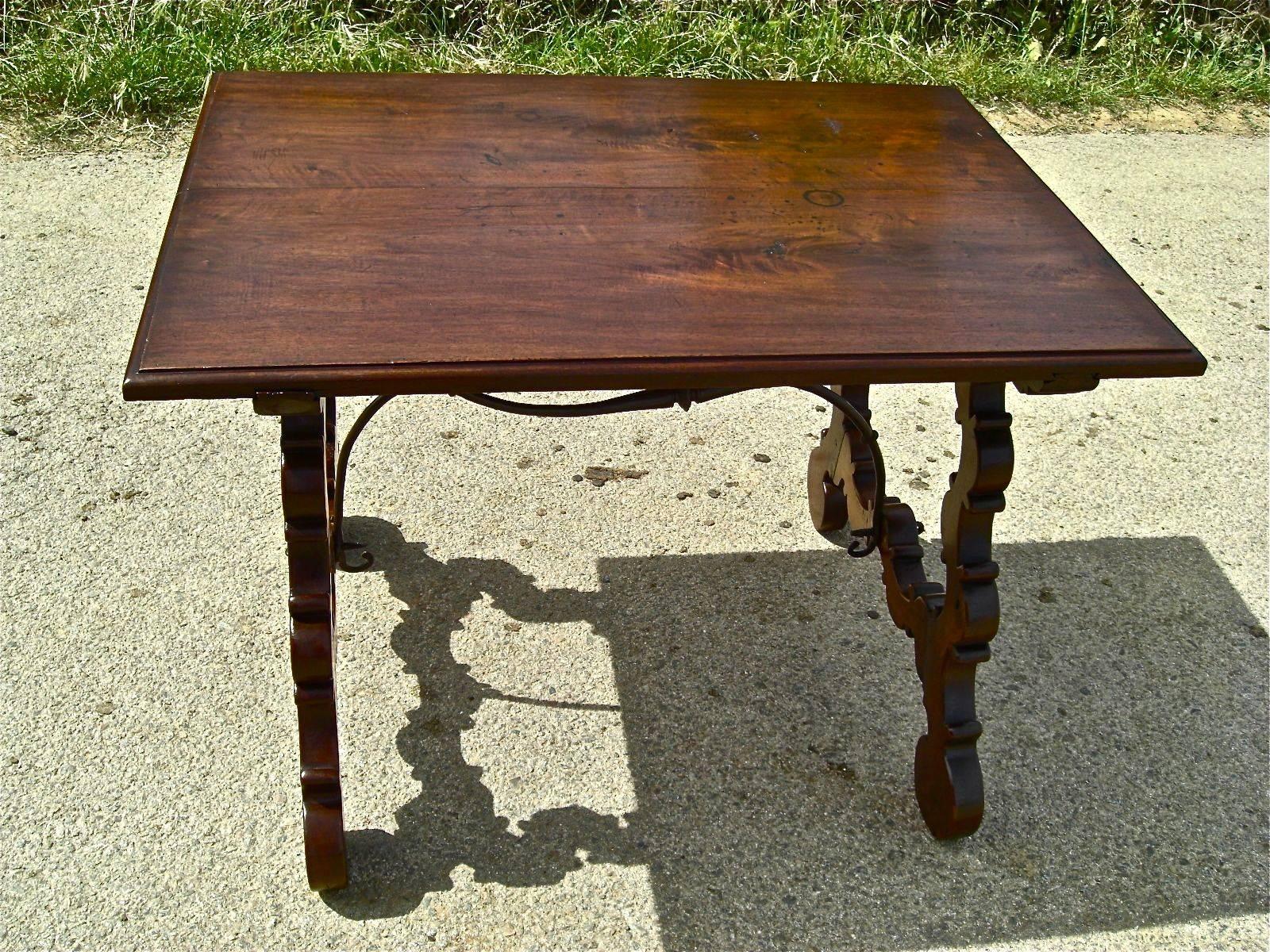 This lovely walnut lyre leg writing table features a top consisting of
two 16”and wide, 1 ½” thick solid walnut planks, and its original
wrought iron stretchers.

With beautiful original patina and delicately crafted scalloped legs, this table