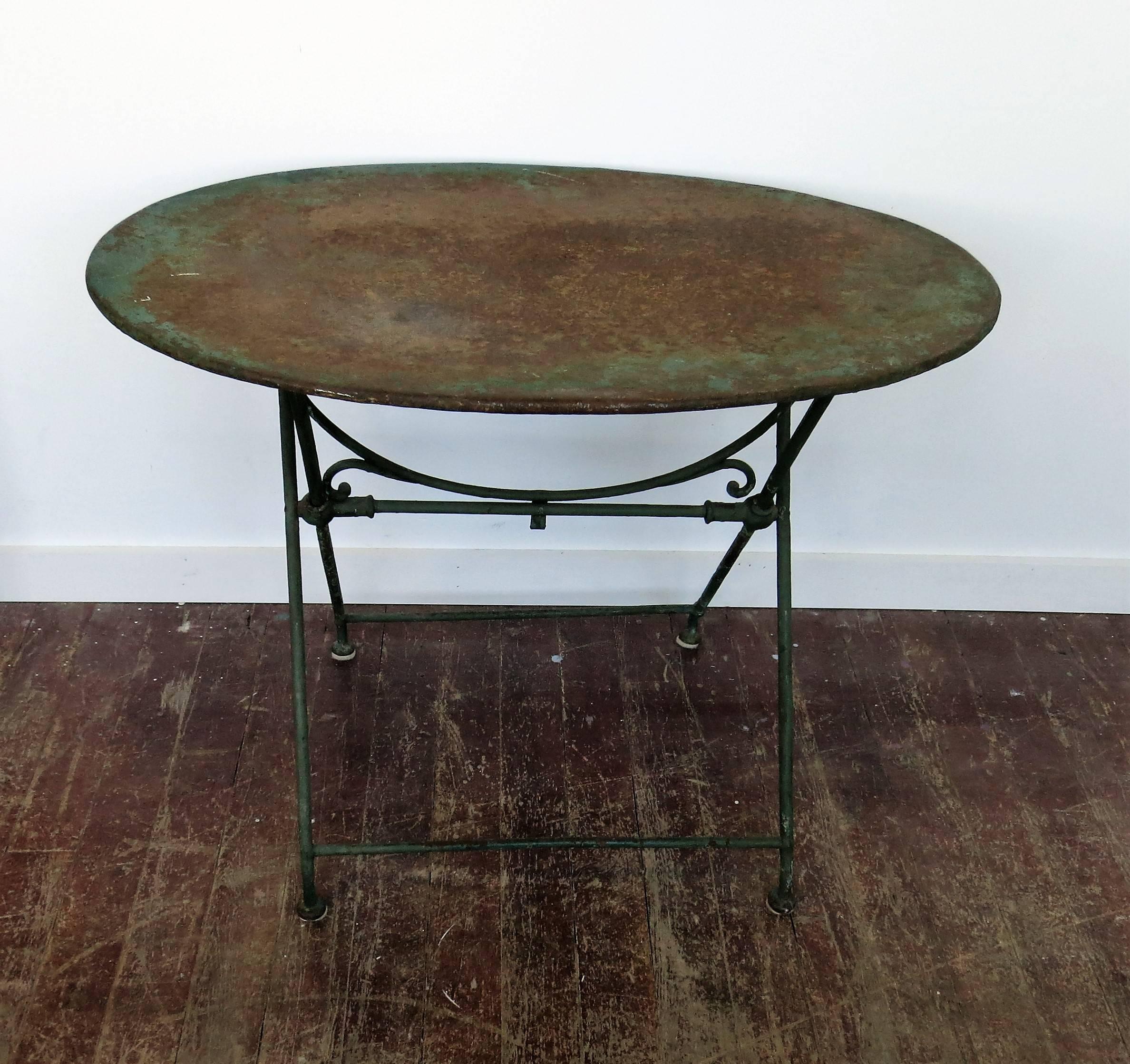 French iron folding table circa 1900 with a nicely rusted top with a few small holes. The top is 24