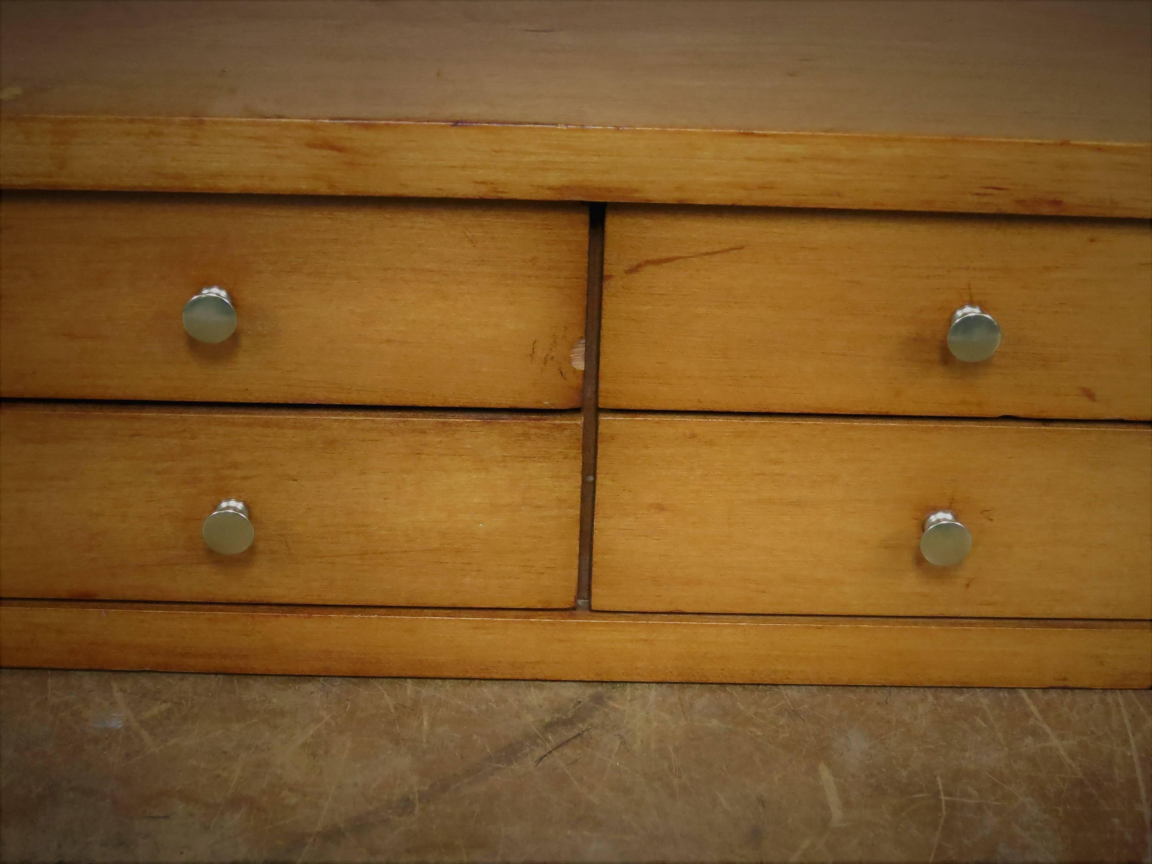 Paul McCobb ten-drawer jewelry chest. The pulls have been replaced. There are a few rings on the top, marks on the edge and a chip on the drawer. There is normal wear. The chest is a nice warm color. Measures: It is 12" deep x 36" wide x