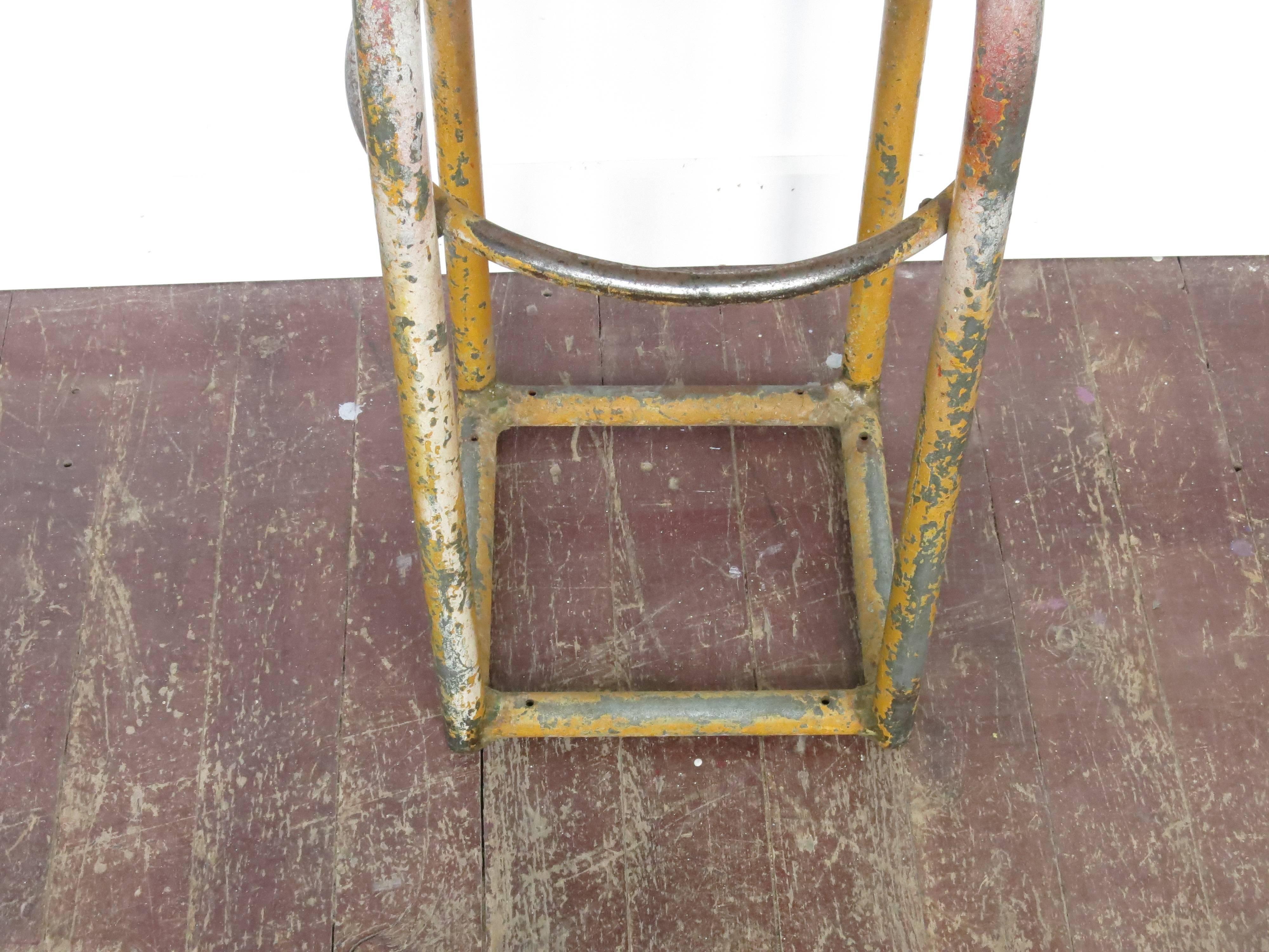Vintage painted metal Industrial shop stool. The seat is 12